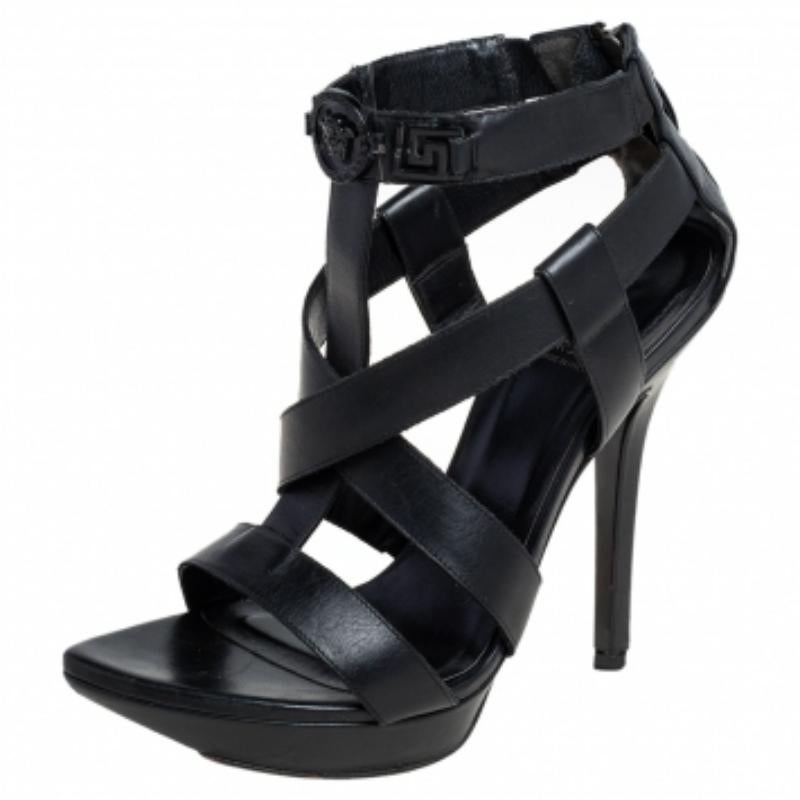 These Versace sandals are crafted from leather and feature a lovely silhouette accented with strappy uppers, a zipper fastening on the counters, platforms, and high heels. They flaunt a tonal Medusa motif on the ankles. Pair them with shift dresses