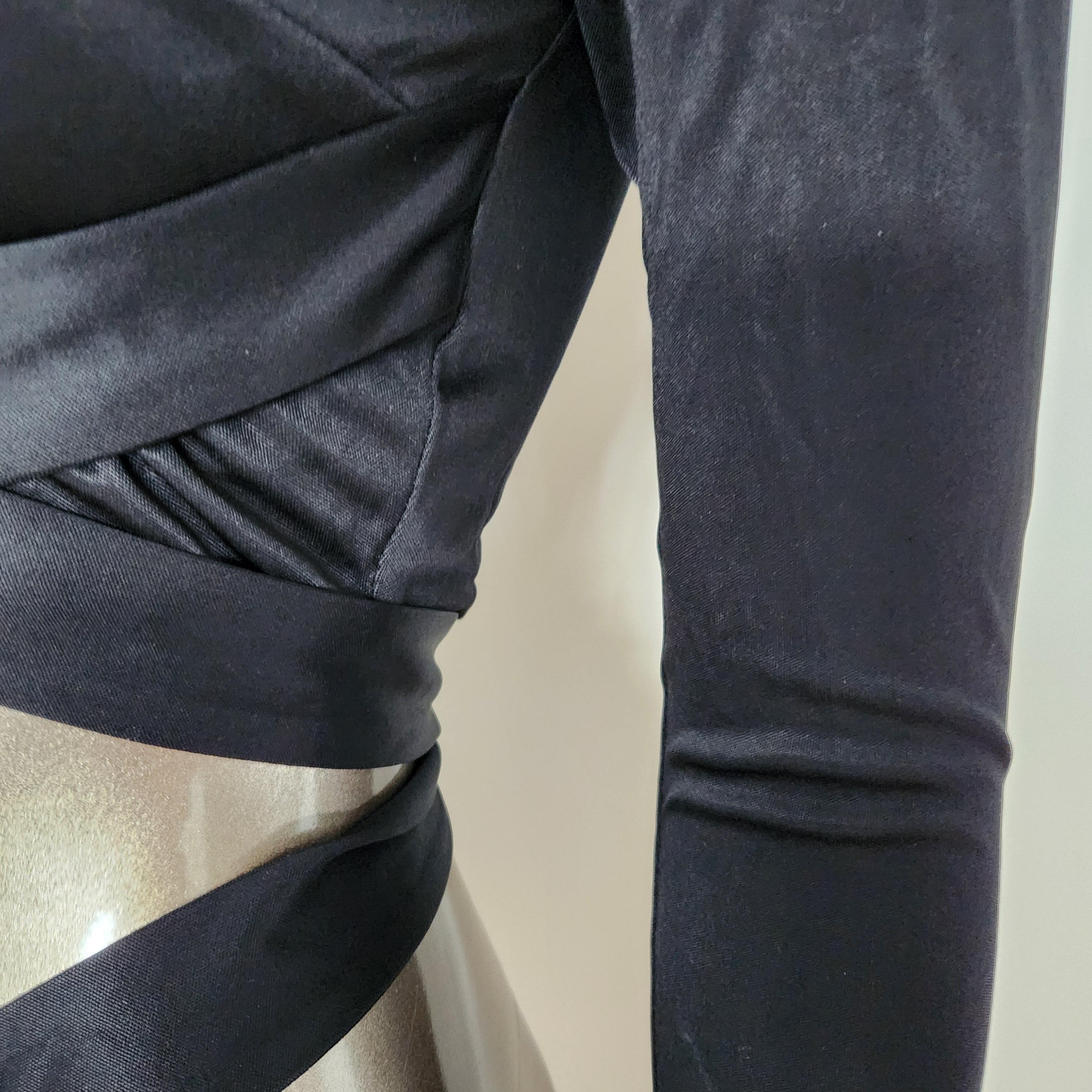 Fai colpo con questo audace e sofisticato top Versace, realizzato in elegante tessuto nero elasticizzato. Progettato con una vestibilità aderente al corpo, questo top a maniche lunghe presenta l'iconica cintura Medusa dorata in vita, che aggiunge