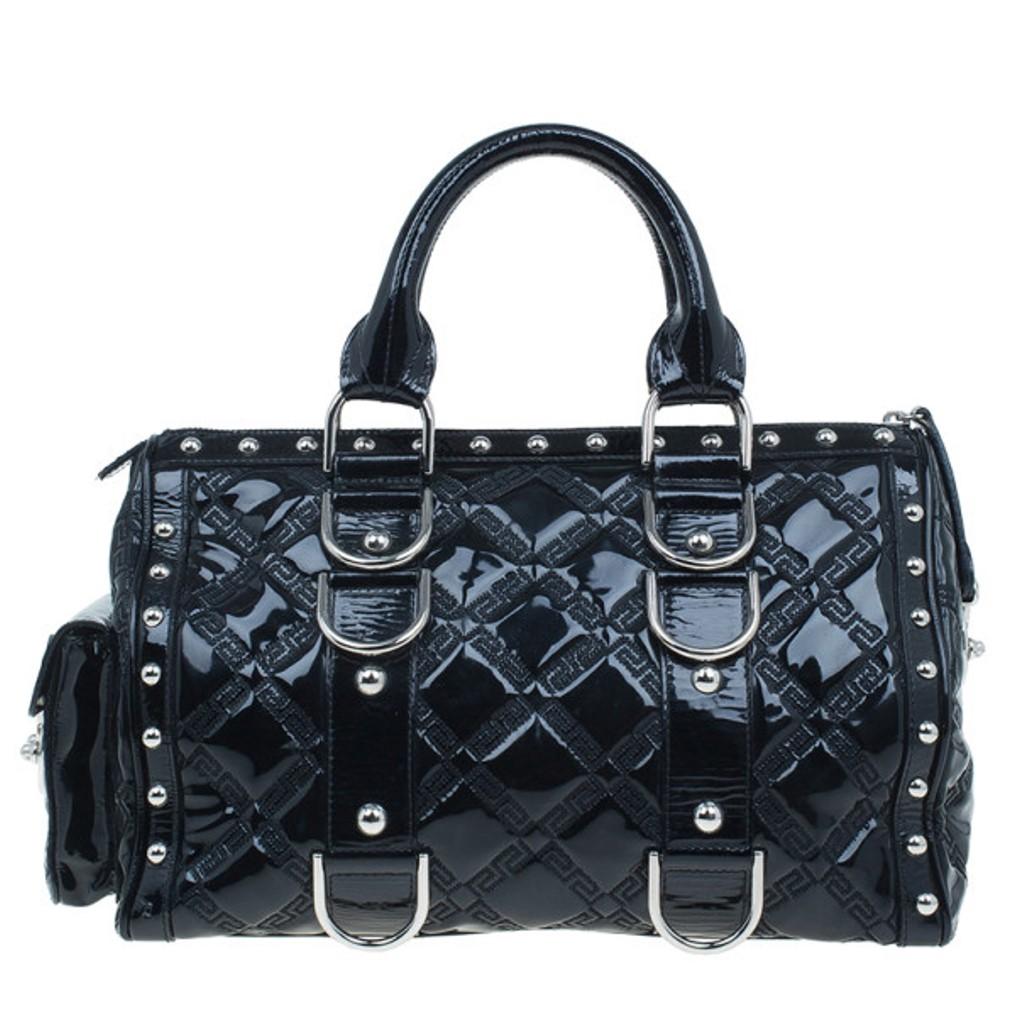 This over the top Versace ‘Snap Out of It’ satchel is a bold statement making bag from the fashion forward Italian label. Crafted from black quilted Versace logo patent leather, it is accented with black braided handles, a flap pocket on the left