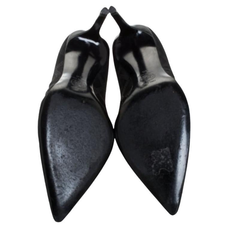 Magnifiquement conçue, cette paire d'escarpins présente un magnifique corps en toile enduite de la signature. Ces escarpins, de la maison de luxe Versace, sont ornés d'un logo sur l'empeigne et d'un bout pointu. Cette paire d'escarpins noirs