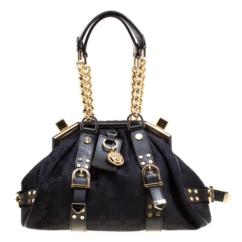The Madonna Boston bag from Versace is made from signature fabric and enhanced with leather. It comes with thick chained handles and a logo charm on the front. It is lined with fabric on the inside and will easily hold your necessities.

Includes: