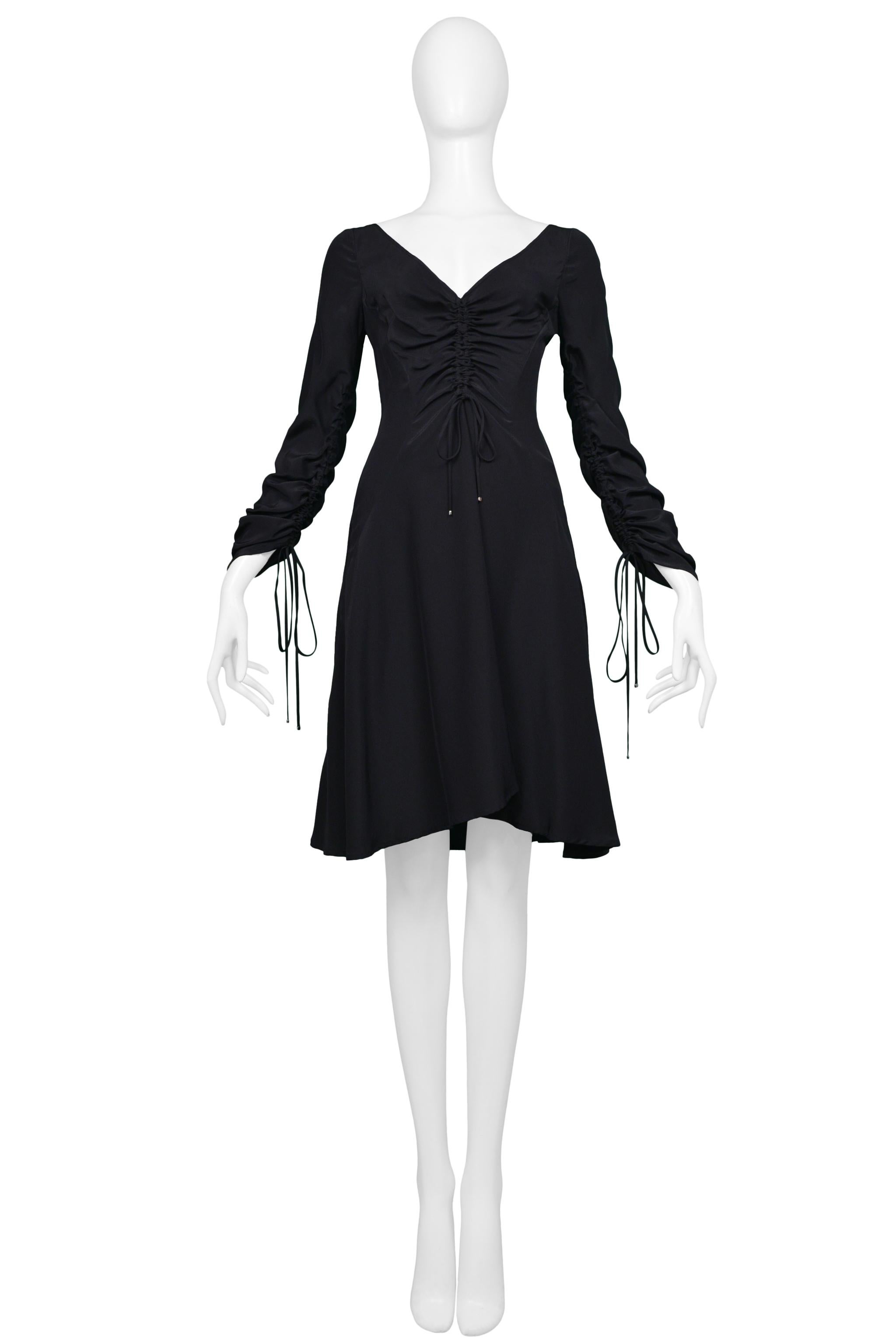 Resurrection Vintage est heureux d'offrir une robe de jour en soie noire Versace avec un décolleté en V avec cordons, des manches longues avec cordons, une fermeture à glissière au dos, et  une silhouette facile et sexy.e 40

Versace
Fabrice : 100%