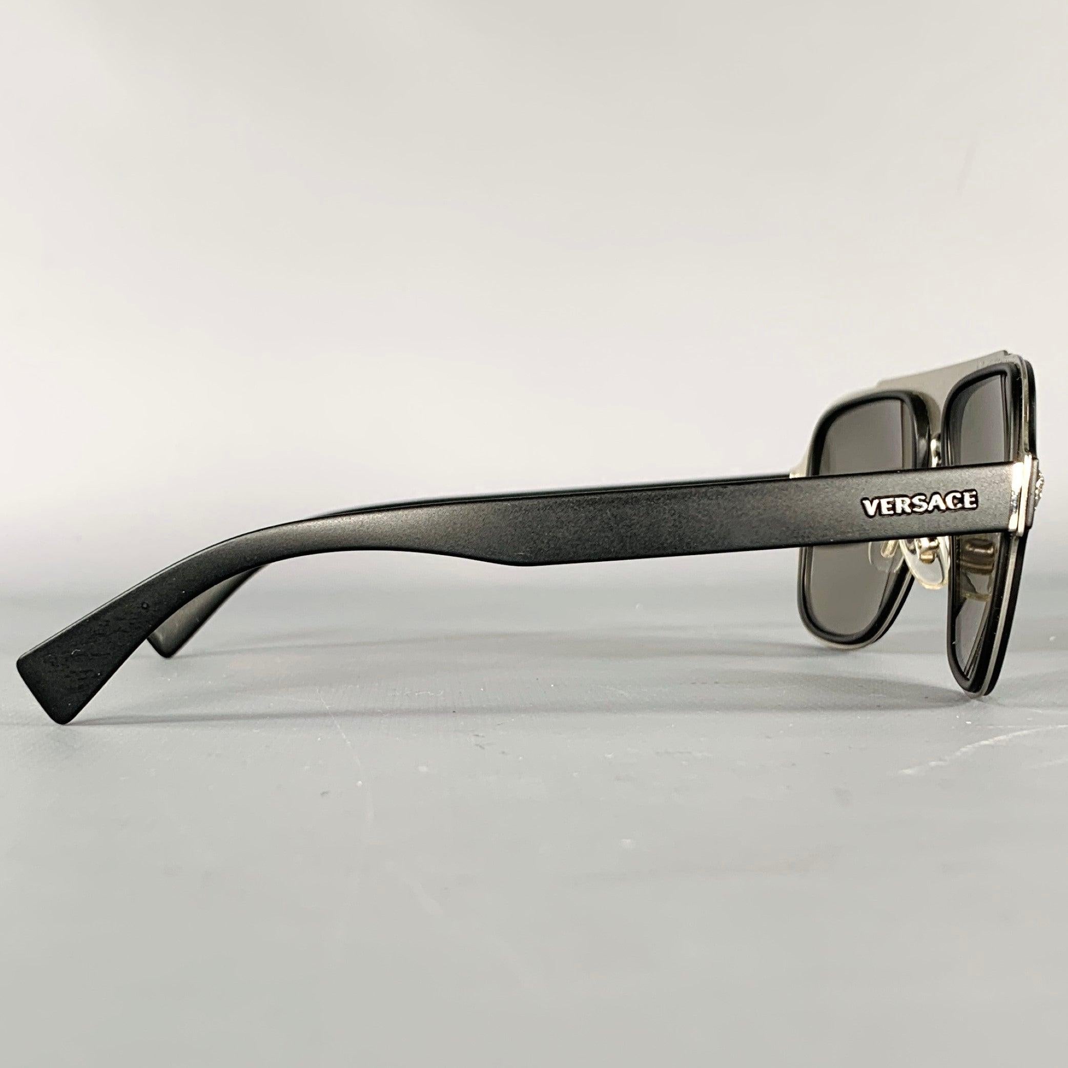 VERSACE
sunglasses in a
black and silver tone metal featuring a teardrop shape, silver tone Medusa heads details, and reflective lenses. Made in Italy.Excellent Pre-Owned Condition with Case. Hinges are slightly loose on case. 

Marked:  
DV1859129
