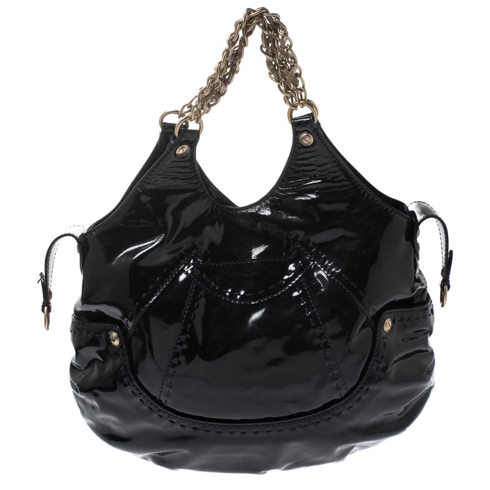 This stylish shoulder bag from Versace in stylish and one-of-a-kind. Crafted in Italy, it is made from glossy patent leather and carries a lovely shade of black. It is held by dual chain handles and the exterior is beautified with stitch detailing