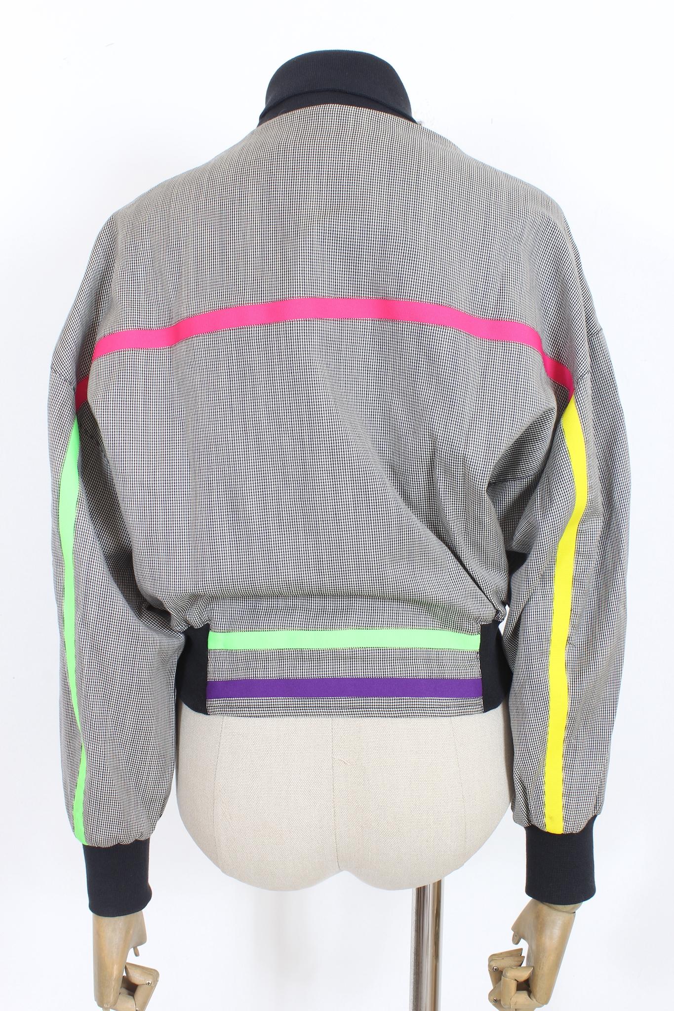 Zeigen Sie zeitlosen Stil mit dieser Versace Vintage 90s Bomberjacke. Diese stilvolle Jacke aus feinster Baumwolle ist mit einem ikonischen Karomuster in Schwarz und Weiß versehen und wird durch fluoreszierende Streifen und einen Reißverschluss