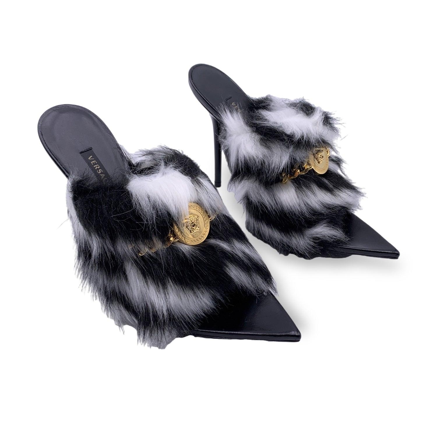 Versace heeled Sandals Mules. Black leather with zebra-effect faux fur. Golden Medusa and chain detailing on the upper. Pointed toe. Heels height: 4.25 inches - 11 cm. Size: EU 38.5 (The size shown for this item is the size indicated by the designer