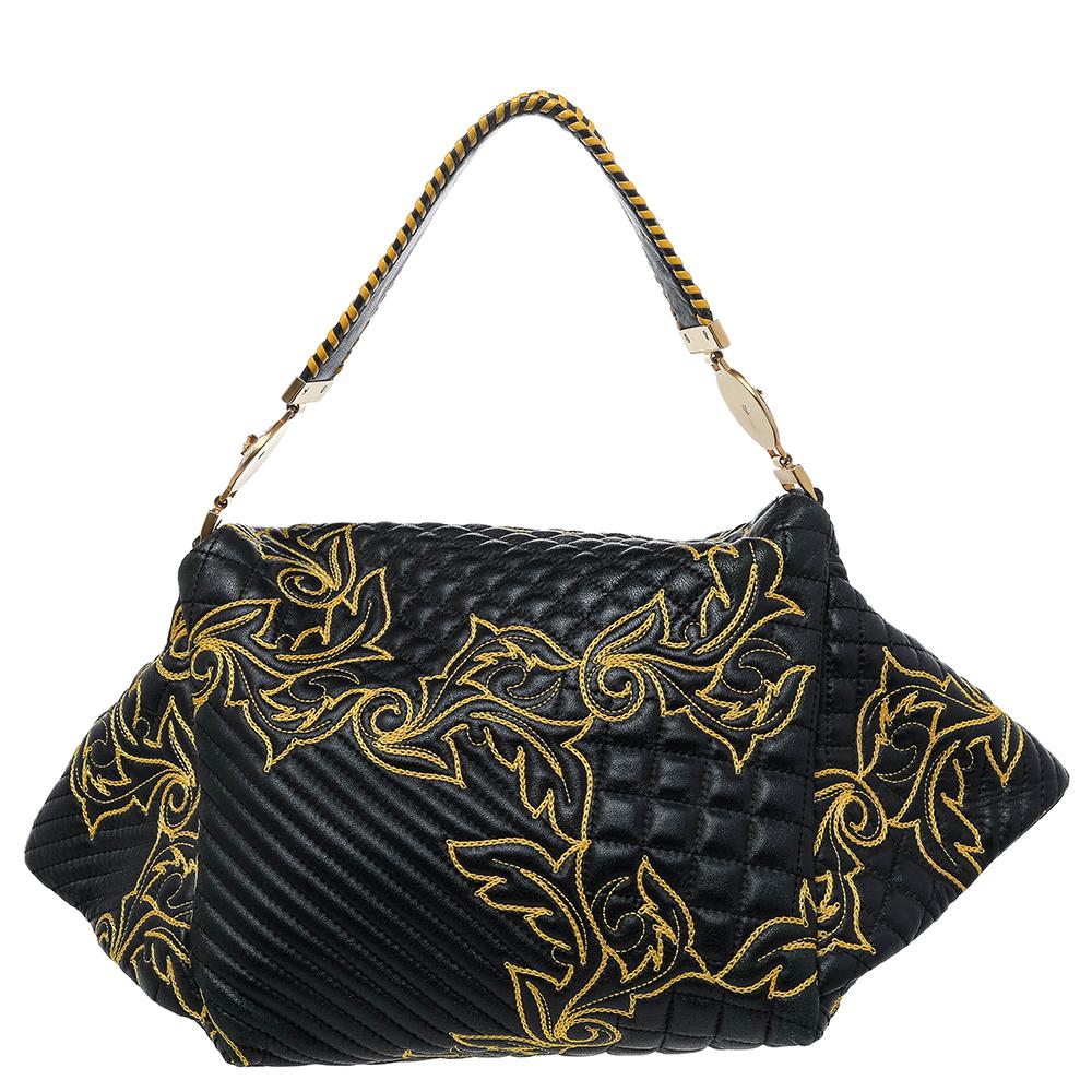 This Versace bag delights not only with its appeal but craftsmanship as well. It is held by a single handle, adorned with lovely floral stitching all over, and equipped with a spacious satin interior. The unique shape, the notable Medusa logo in