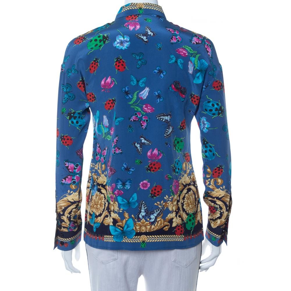 This artsy shirt from Versace is crafted from the finest quality silk. The full-sleeved shirt has a baroque butterfly & ladybug print in blue shades throughout. Pair it with plain trousers or a skirt.

