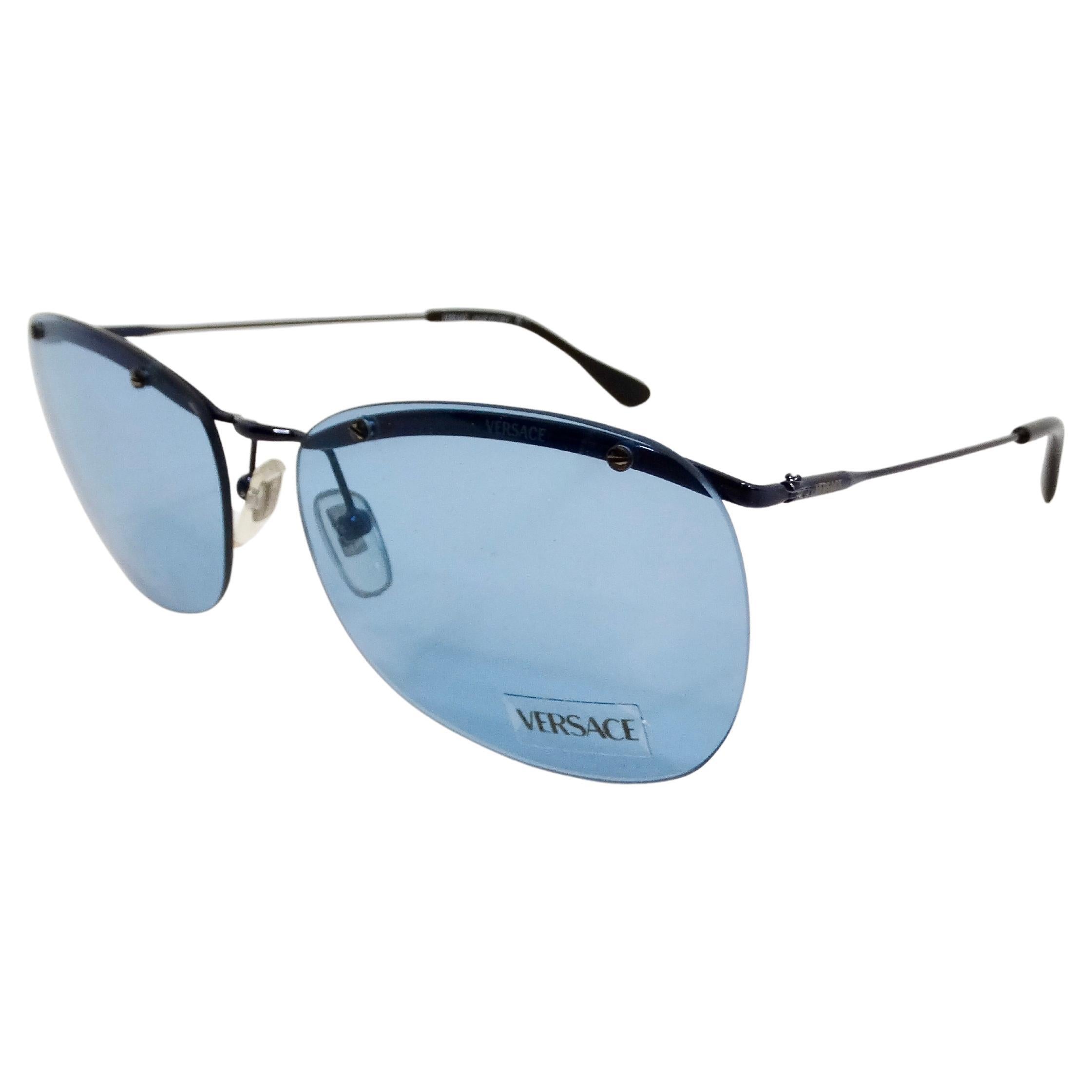 The Versace Blue Frameless Aviator Sunglasses from the 1990s epitomize bold luxury and timeless style. Crafted with a striking blue hue, these sunglasses feature a frameless design that exudes a sleek, modern aesthetic while still paying homage to
