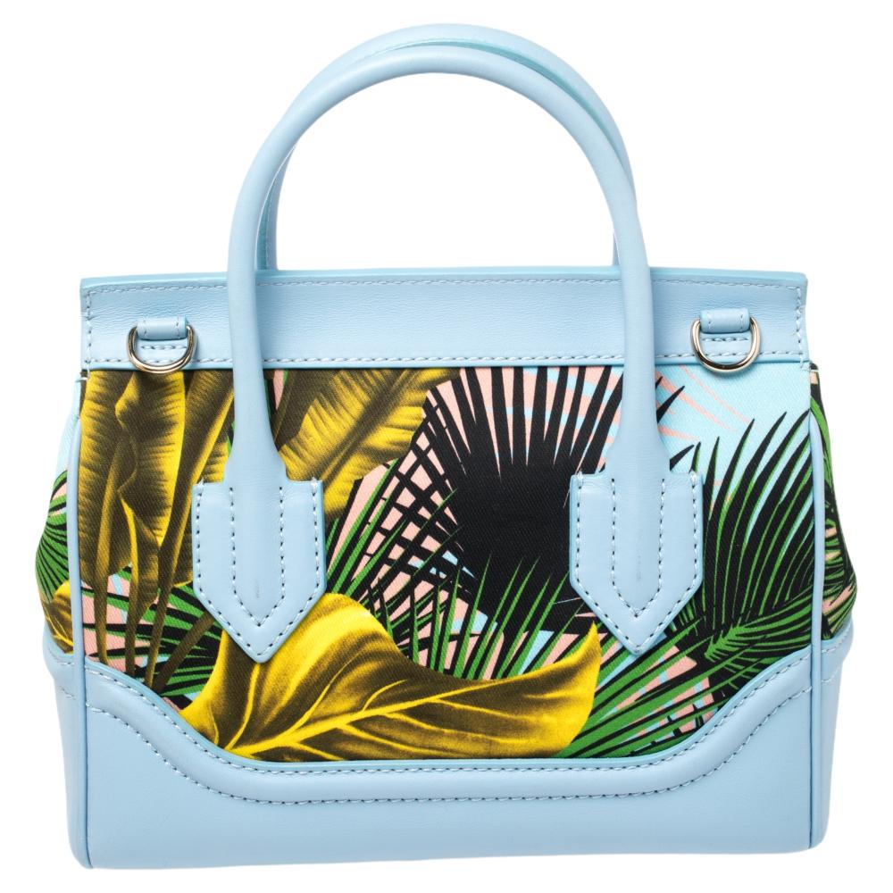 This Palazzo Empire tote from Versace is an alluring design. The bag comes in a luxurious blue leather & 'Desert Palm' printed fabric exterior, designed with the signature Medusa motif on the flap. It features a spacious interior and dual top