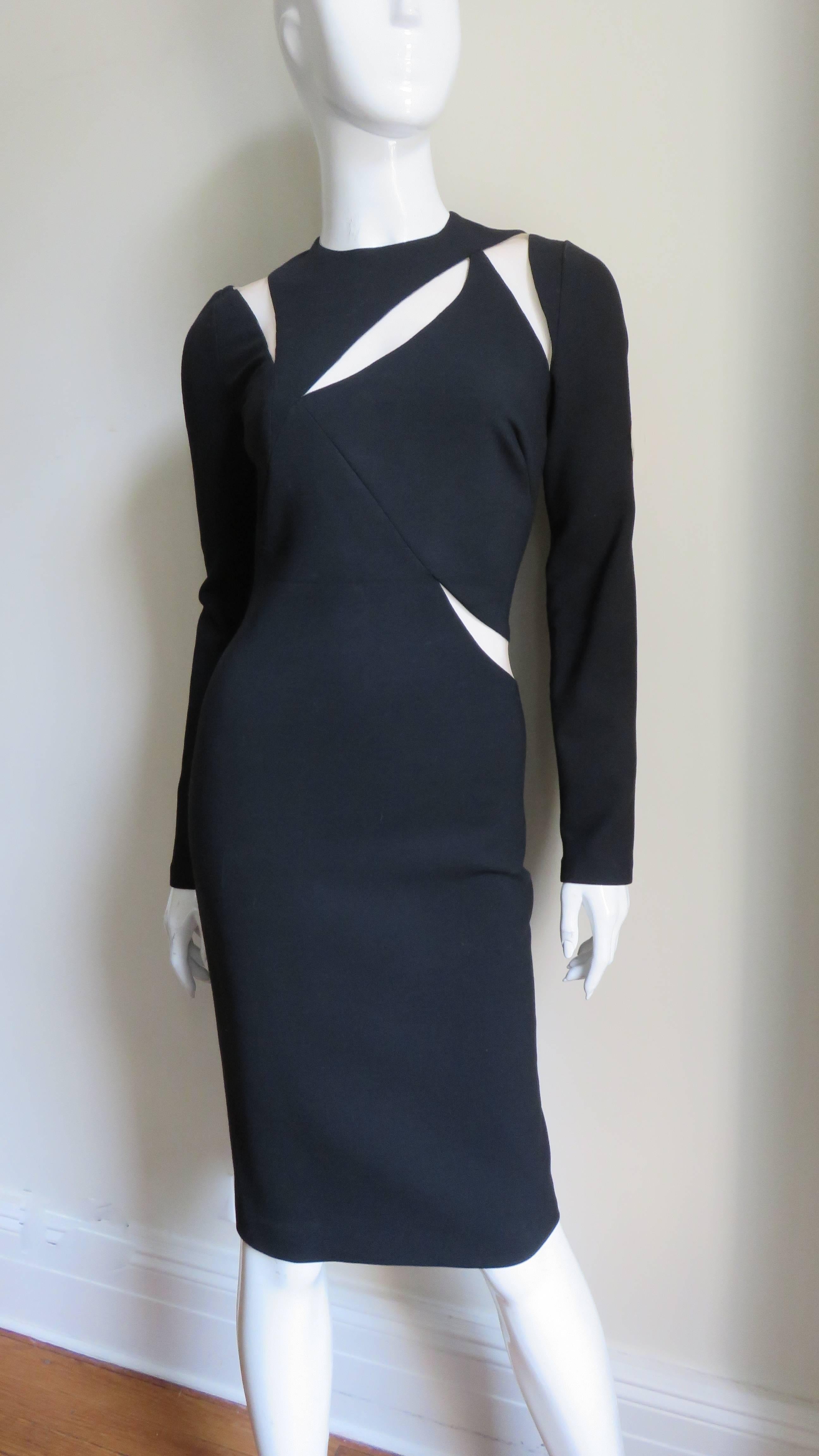A fabulous fine black wool jersey dress from Versace.  It is semi fitted with long sleeves, a crew neck and fabulous nude mesh covered wedge and ray shaped cut outs following the intricate seaming of the bodice, waist, neckline, shoulders and across