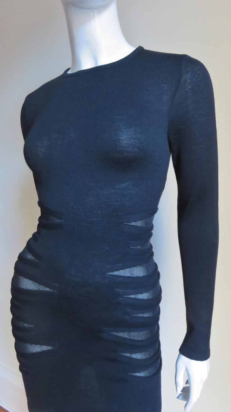 A fabulous black light weight wool knit dress from Versace. It is fitted with long sleeves and a crew neckline.  The sides of the waist and hips have mesh covered cut outs in varying sizes.  It is unlined and slips on over the head.
Fits sizes