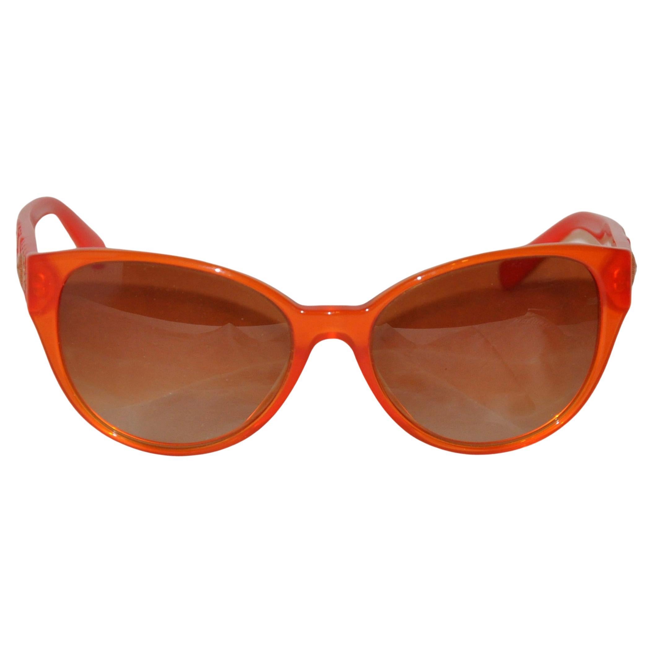 Bold Tangerine mit charakteristischem Logo und goldenen Nieten-Sonnenbrillen von Versace