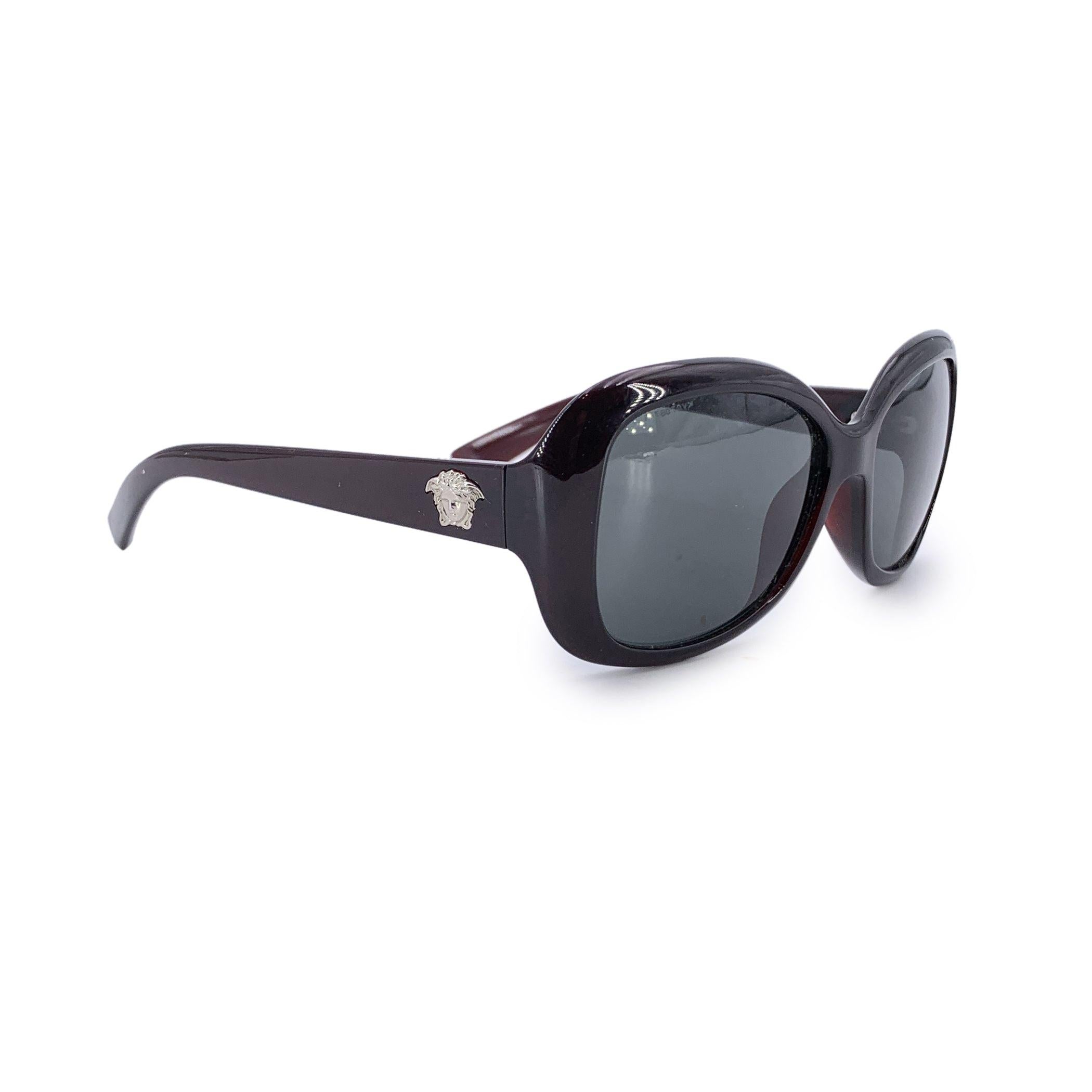 Ces lunettes de soleil pour femme Versace 4187 388/87 sont d'une élégance audacieuse. Elles sont signées de la maison qui a fait s'entrechoquer mythe et modernité. Fabriquées dans un plastique bordeaux riche, ces montures carrées surdimensionnées