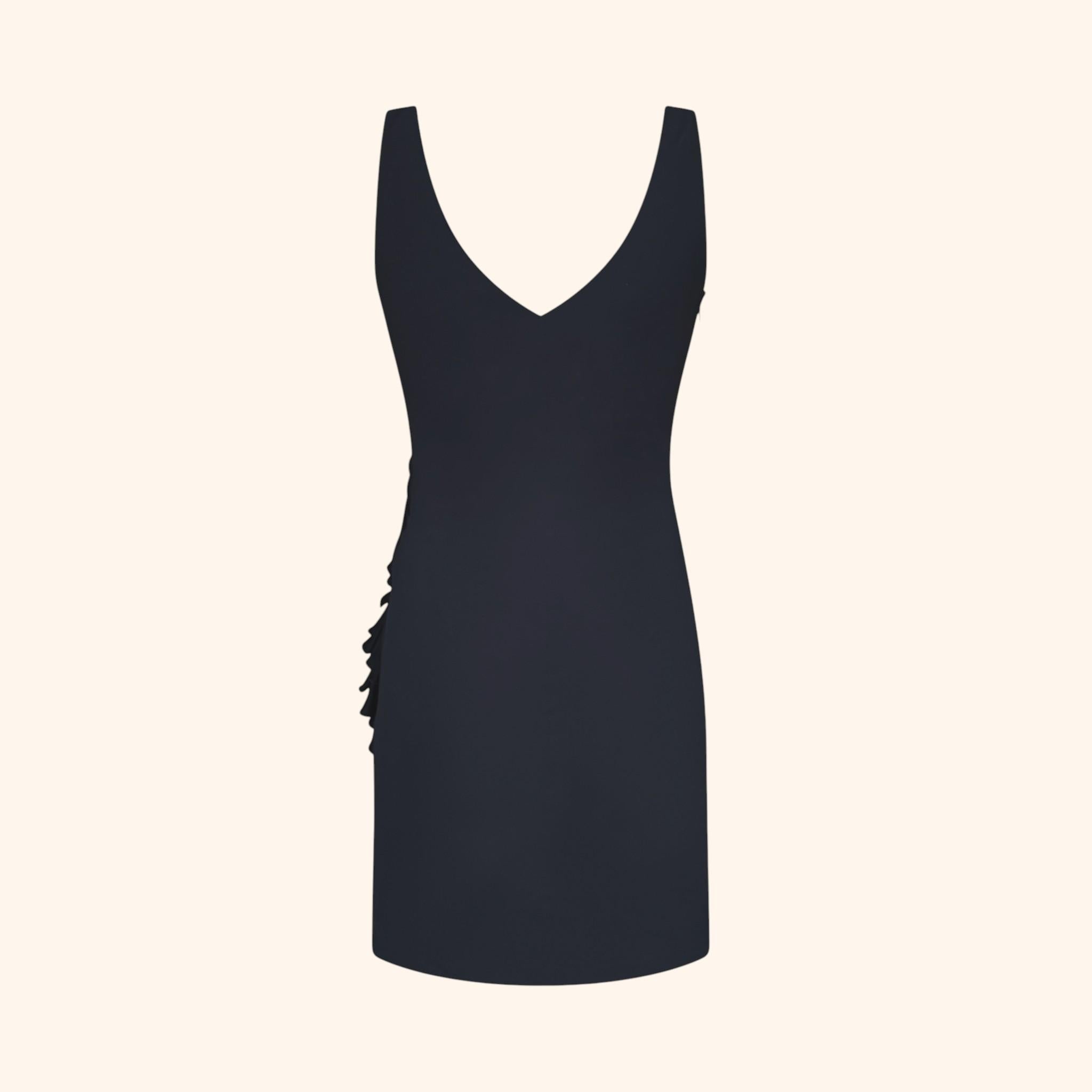 Élégante robe noire Versace de la collection Automne/Hiver 2006, présentant une silhouette ajustée et des volants asymétriques sur le devant.
Cette pièce met en valeur le drapé raffiné et les lignes sculpturales caractéristiques de Versace au milieu