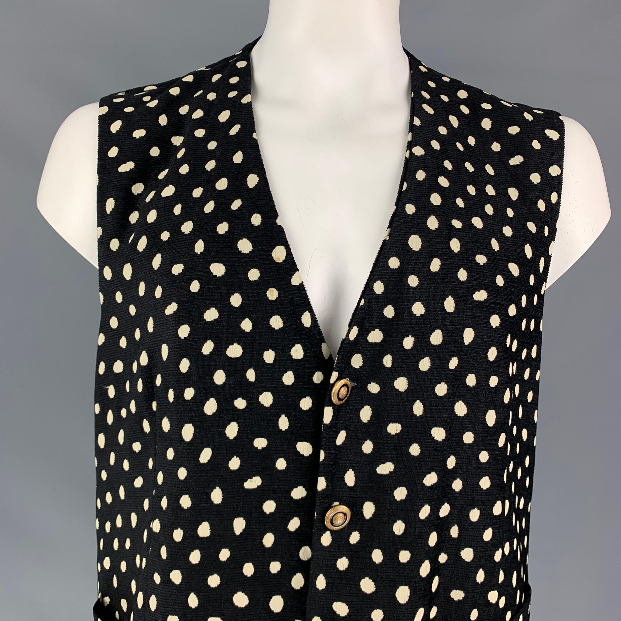 VERSACE CLASSIC vest comes in a black & white dot print viscose blend featuring slit pockets and a gold tone button closure. Made in Italy.

Very Good Pre-Owned Condition.
Marked: 56

Measurements:

Shoulder: 17 in.
Chest: 46 in.
Length: 24.5 in. 