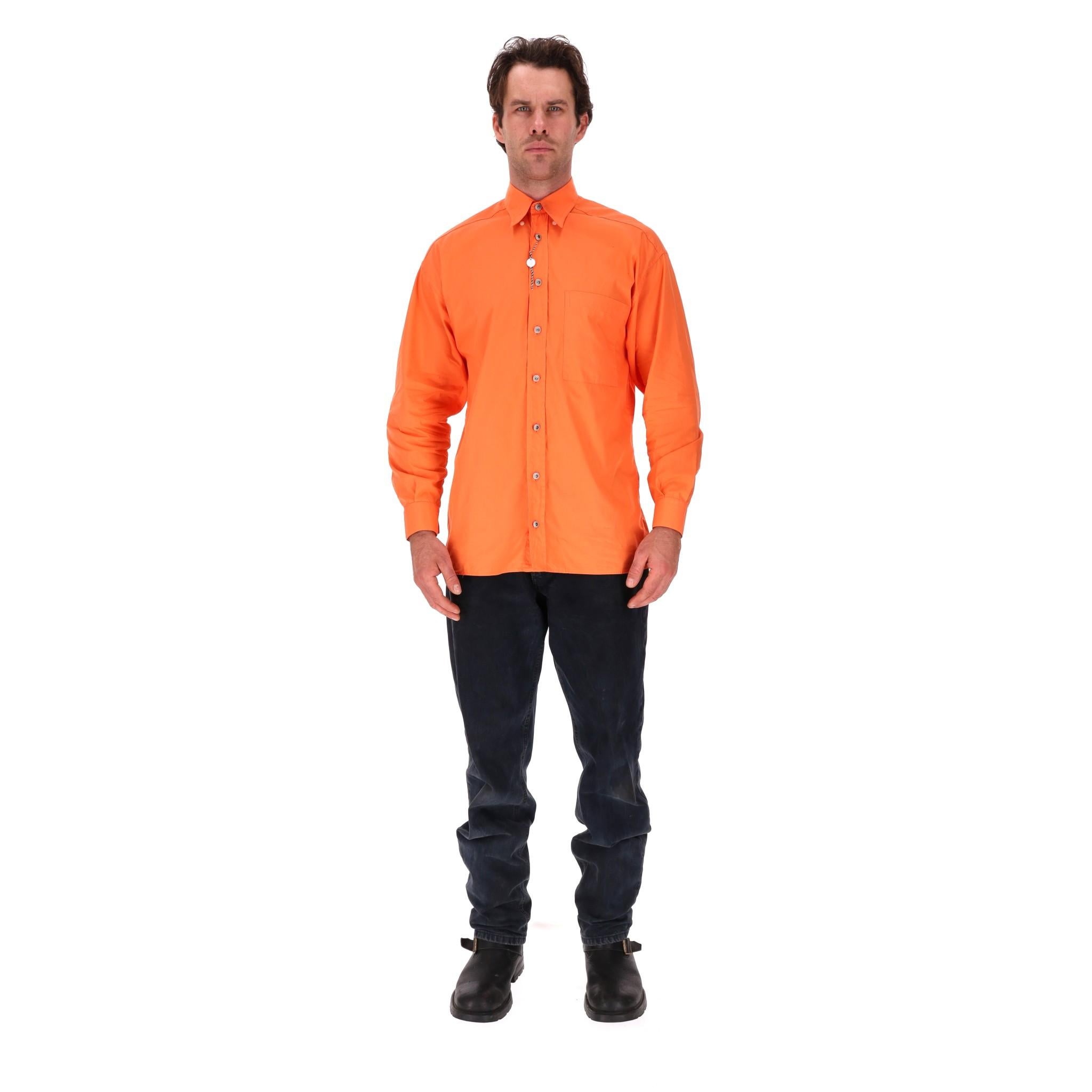 Versace Classic V2 Logo Cotton Shirt

Orange shirt with large logo embroidery to rear. 

Silver button fastening along the centre embossed with 'Versace' and signature Greca pattern.

Classic collar, regular fit and buttoned cuffs. Rrp Approx.