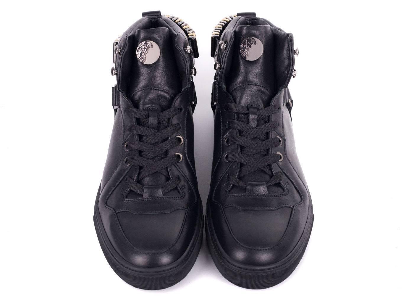 Versace's Hi Top Harness Sneaker took a futuristic turn for your best. This sneaker features it's signature leather strap harness, edgy gunmetal and gold rivets strap, and smooth polished finish. You can pair these shoes will an all black outfit to