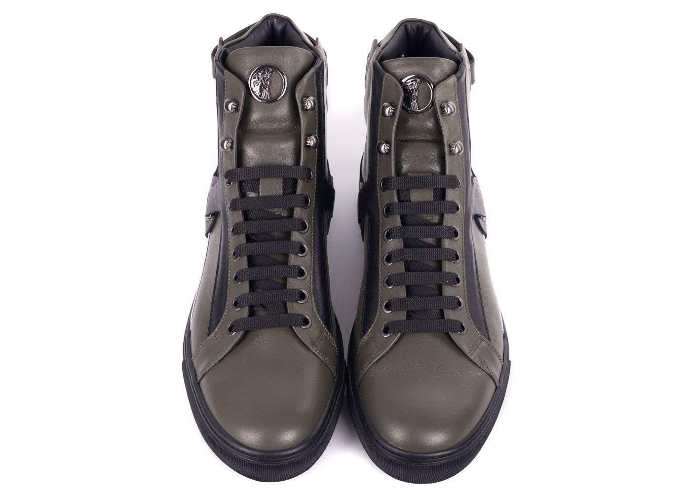 Enter the room in your Hi Top Versace Sneakers. This rich olive green sneakers feature a black leather harness, contrasting white leather panel, and an adjustable heel fastening. These modern designed sneakers will headline the concept of luxury
