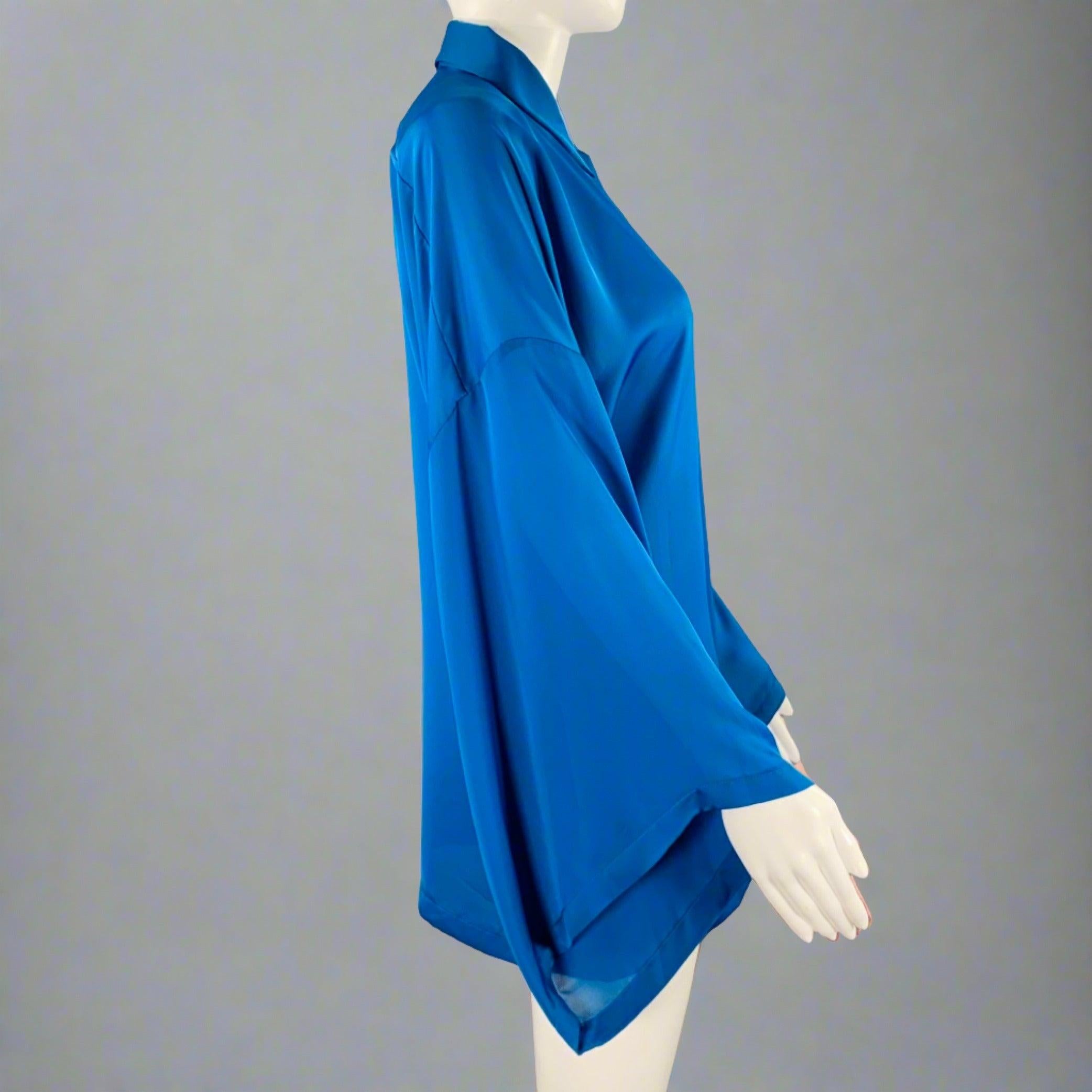 VERSACE COLLECTION blouse
in a blue polyester fabric featuring spread collar, large wing sleeves, and hidden button closure. Made in Italy.Excellent Pre-Owned Condition. 

Marked:   IT 42 

Measurements: 
 
Shoulder: 283 inches Bust: 38 inches