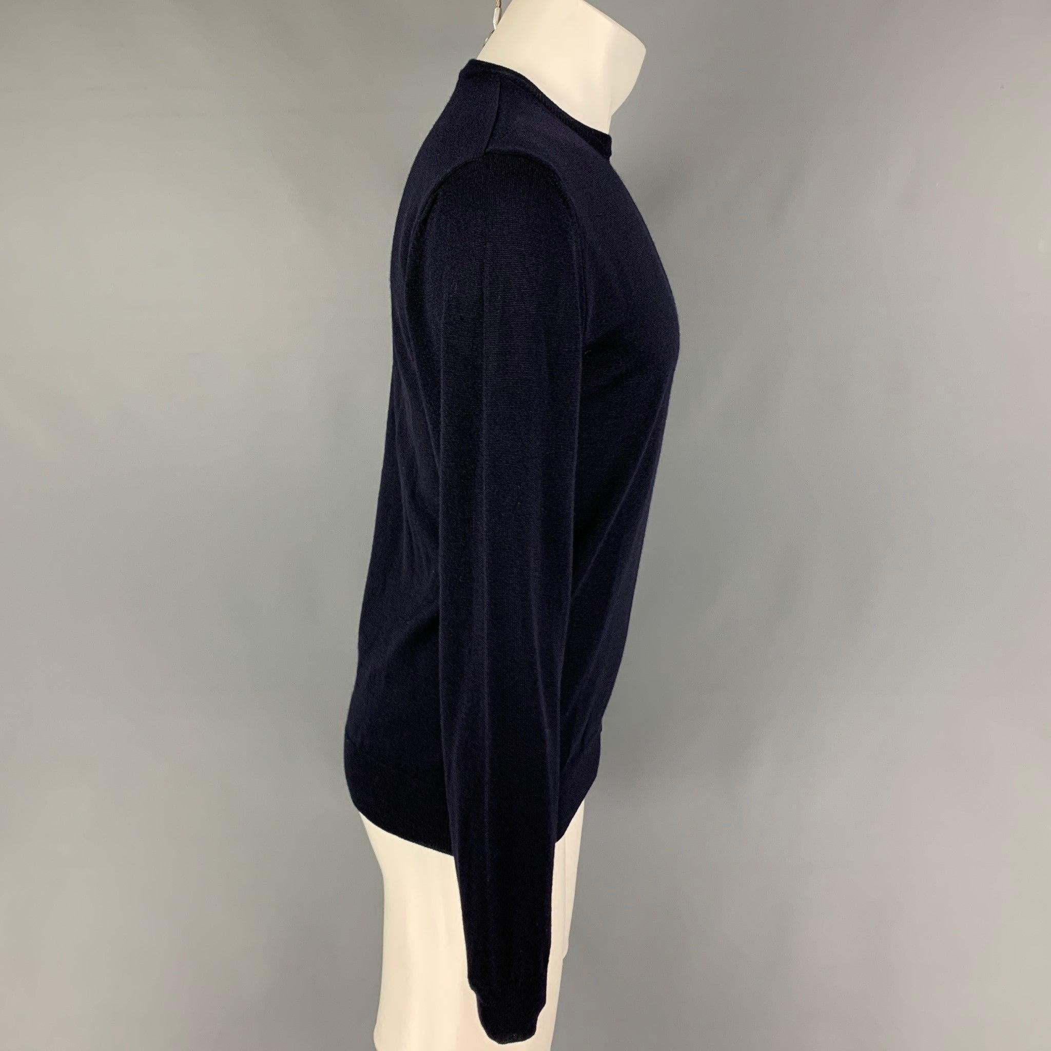 VERSACE COLLECTION pullover comes in a navy knitted merino wool featuring a slim fit, embroidered logo, and a crew-neck.
Very Good
Pre-Owned Condition. 

Marked:   L  

Measurements: 
 
Shoulder: 17 inches  Chest: 38 inches  Sleeve: 28 inches 