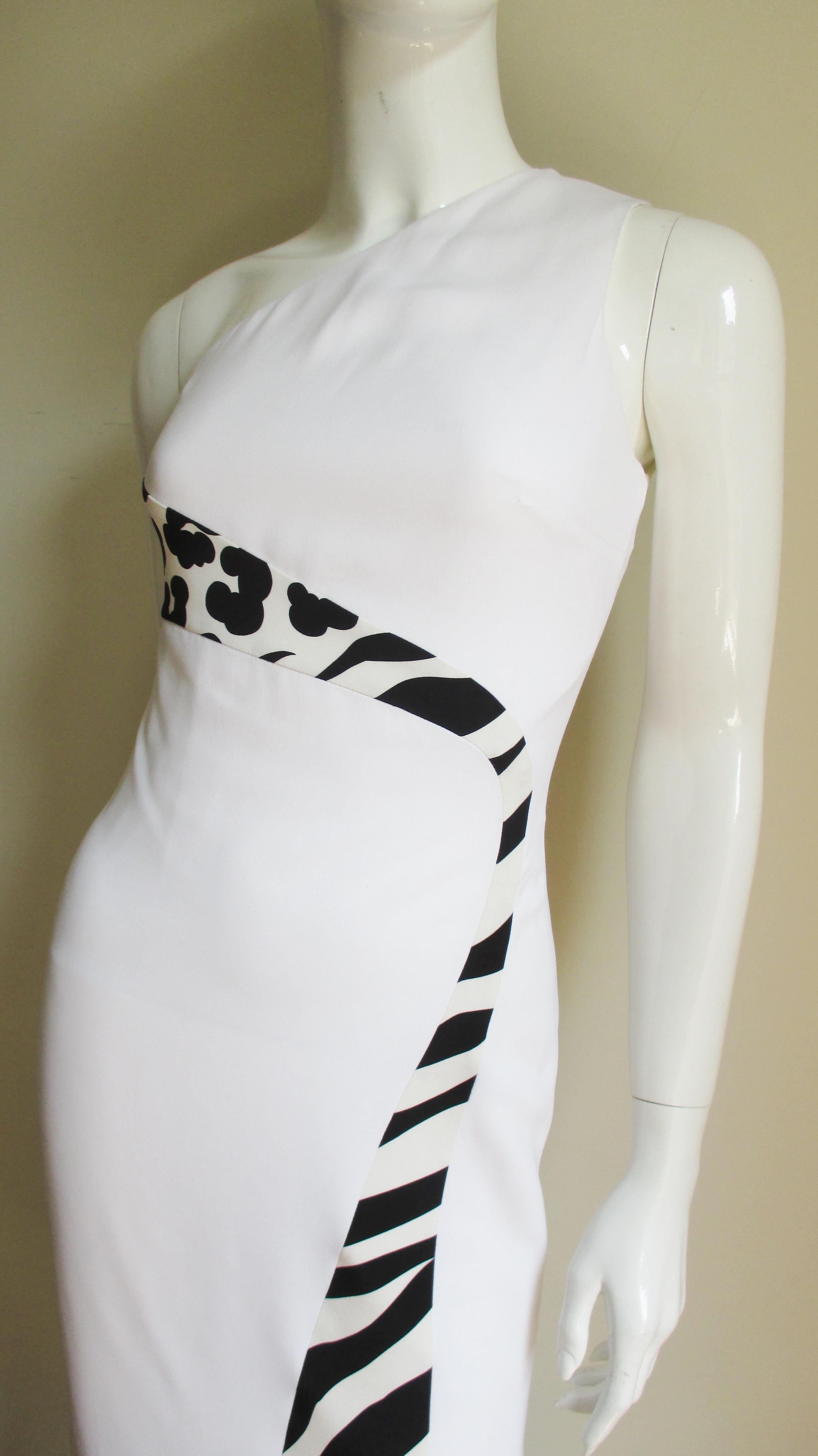 A fitted one shoulder white silk dress with slight stretch from Versace.  It has an inset black and white abstract print panel diagonally crossing the upper back curving around to under the bust then down the front skirt.  It has princess seaming