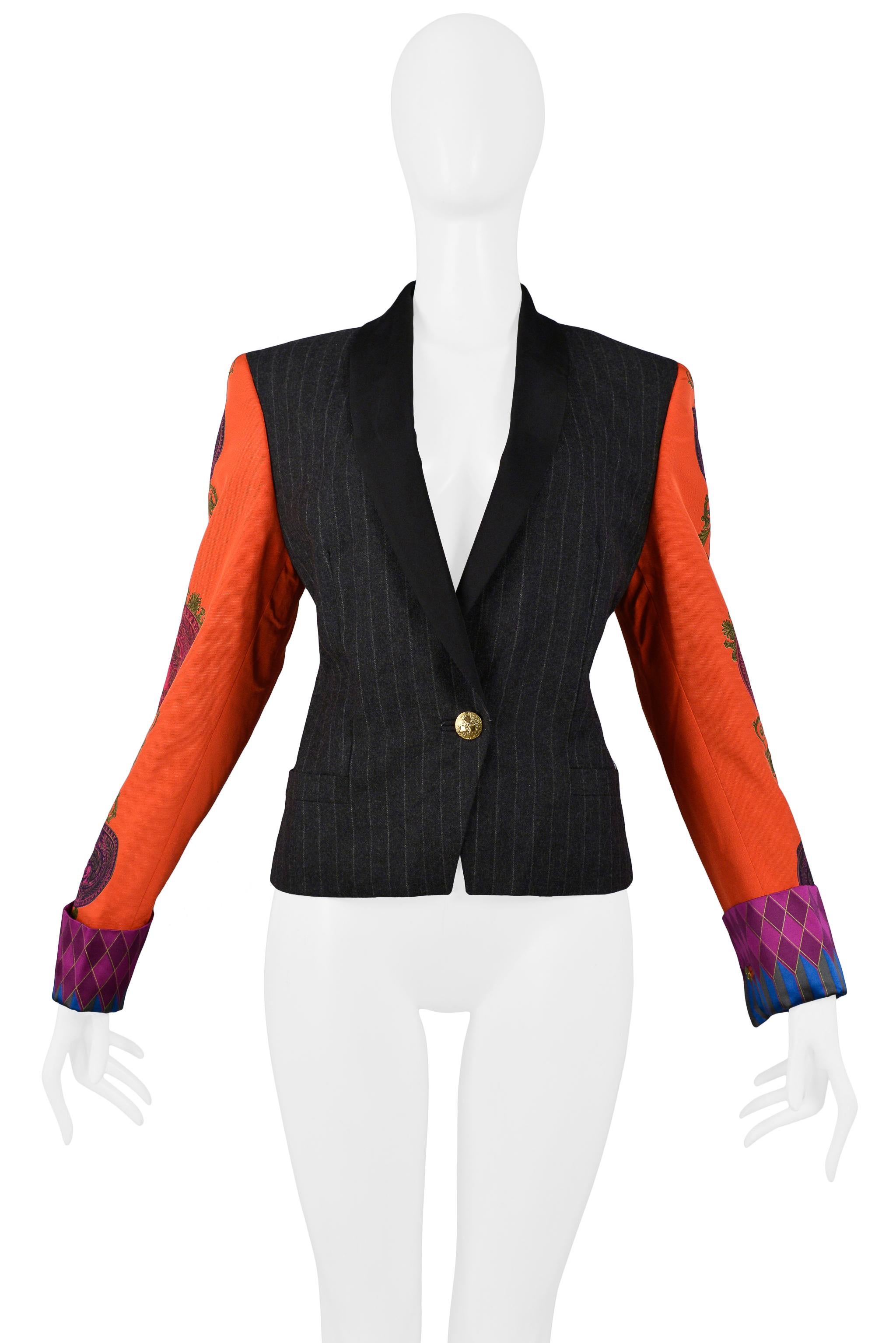 Resurrection Vintage is excited to offer a vintage Versace Couture blazer featuring a wool pinstripe bodice with solid lapels, one gold button closure, side pockets, and red sleeves with Baroque graphic prints and harlequin cuffs. 

Versace