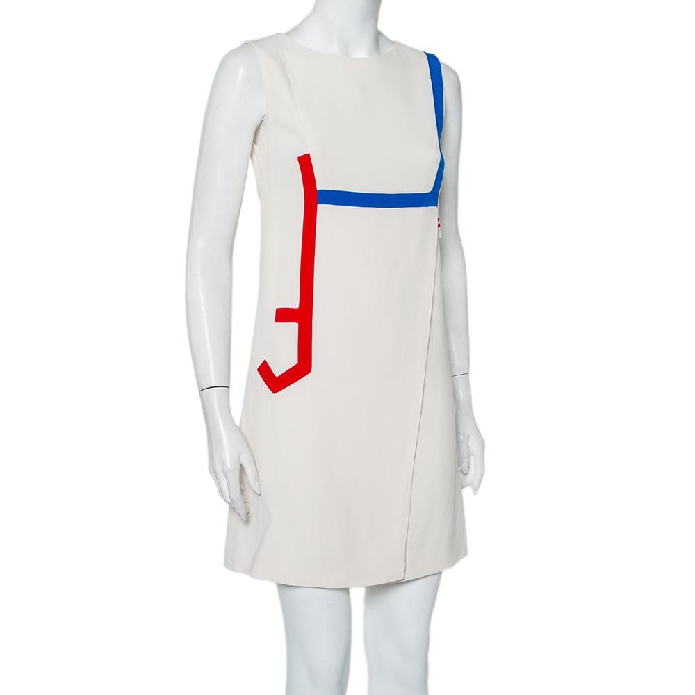 This Versace cream mini dress brings distinct details and a chic silhouette. It is designed with a round neckline, contrast trims on the front in blue & red, and a zip closure. It is made from the finest materials and bound to give you comfort.

