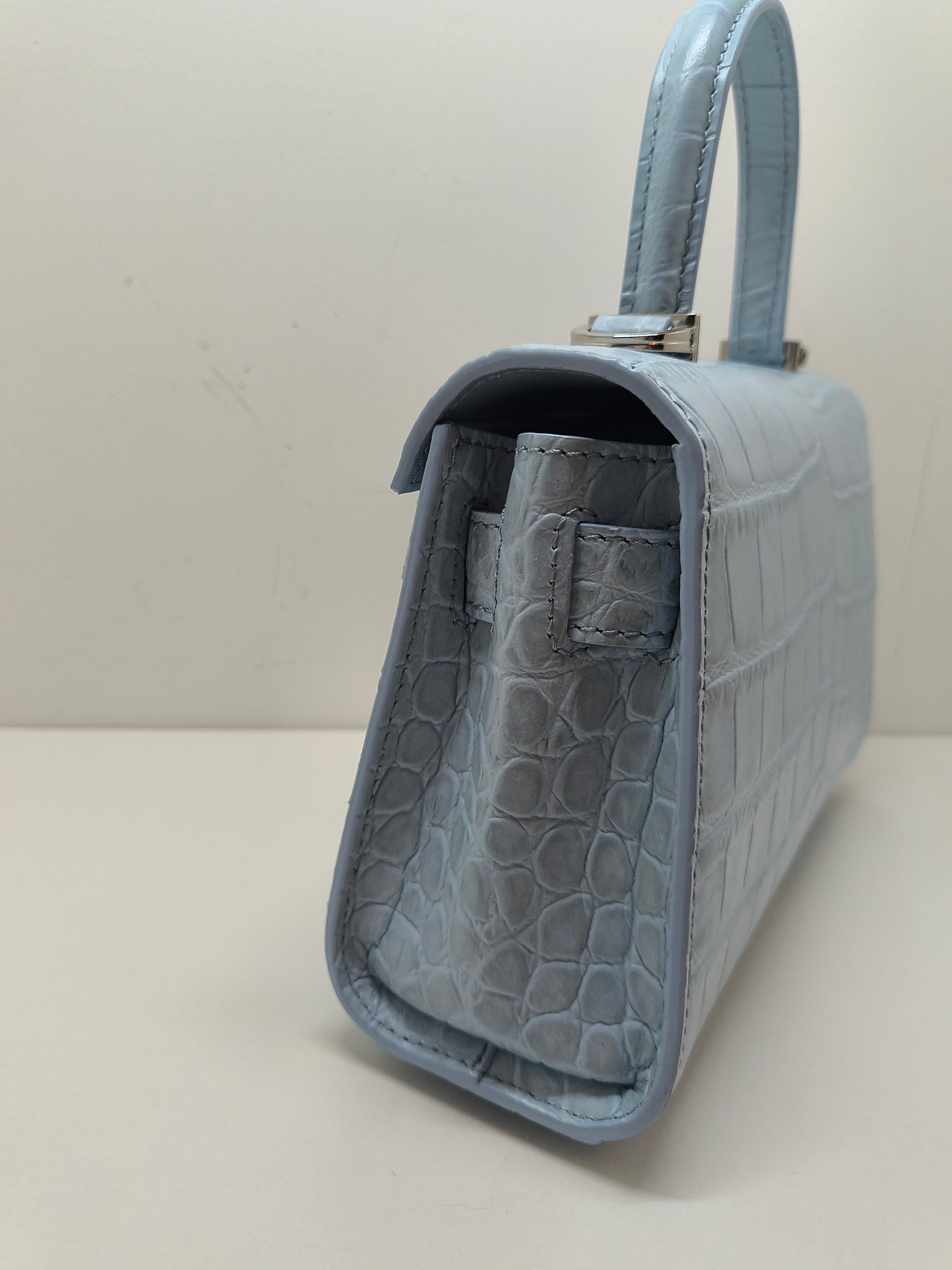 A small handbag with belt detail featuring the Medusa '95 hardware, the iconic House code first seen in the 1995 collections. The top handle design is made from croc-effect embossed leather with a magnetic foldover flap and a detachable crossbody