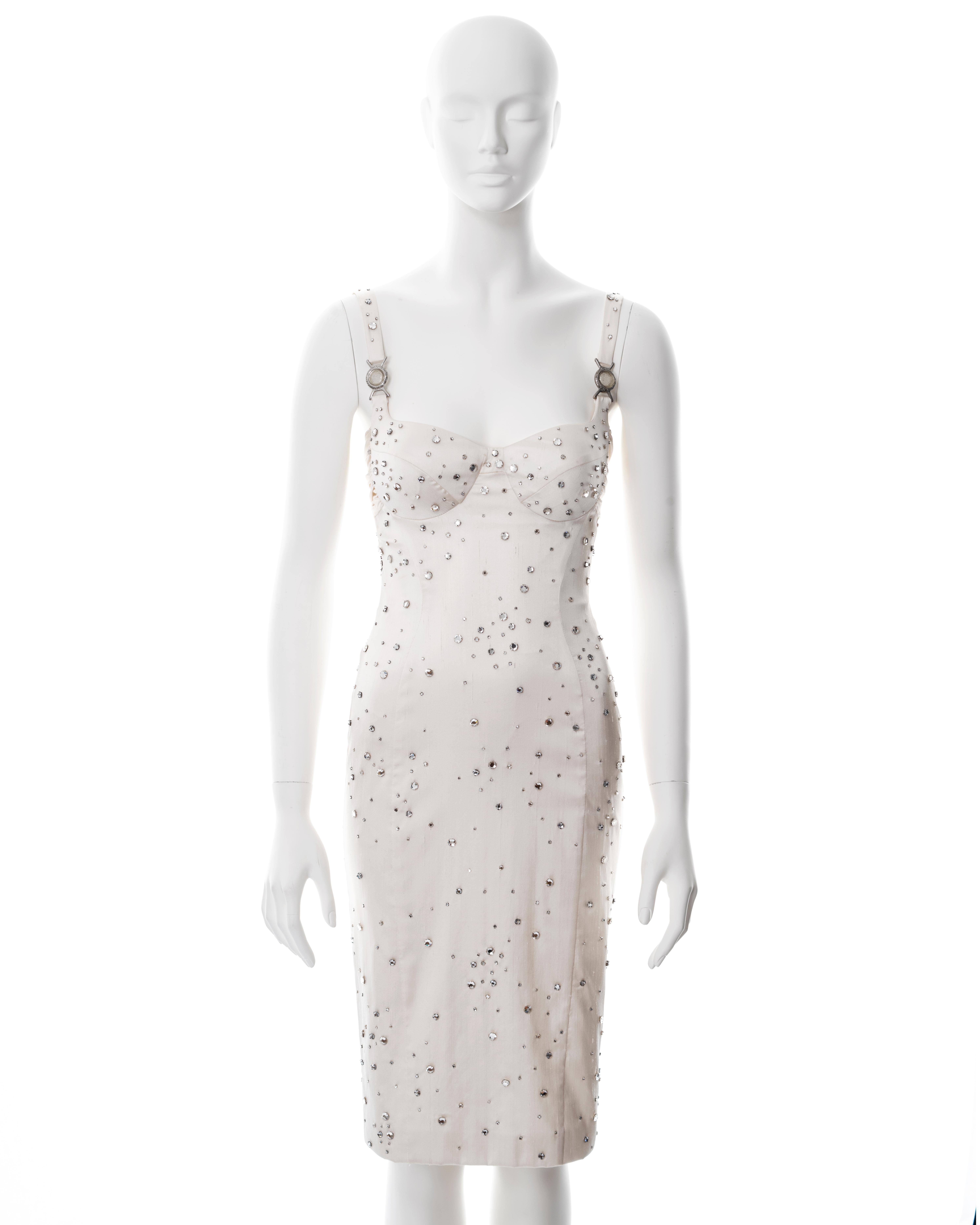▪ Versace ivory silk evening dress
▪ Designed by Donatella Versace
▪ Sold by One of a Kind Archive
▪ Spring-Summer 2005
▪ Constructed from a raw silk and spandex blend with a nubby texture 
▪ Embellished with hundreds of hand-sewn crystals set in