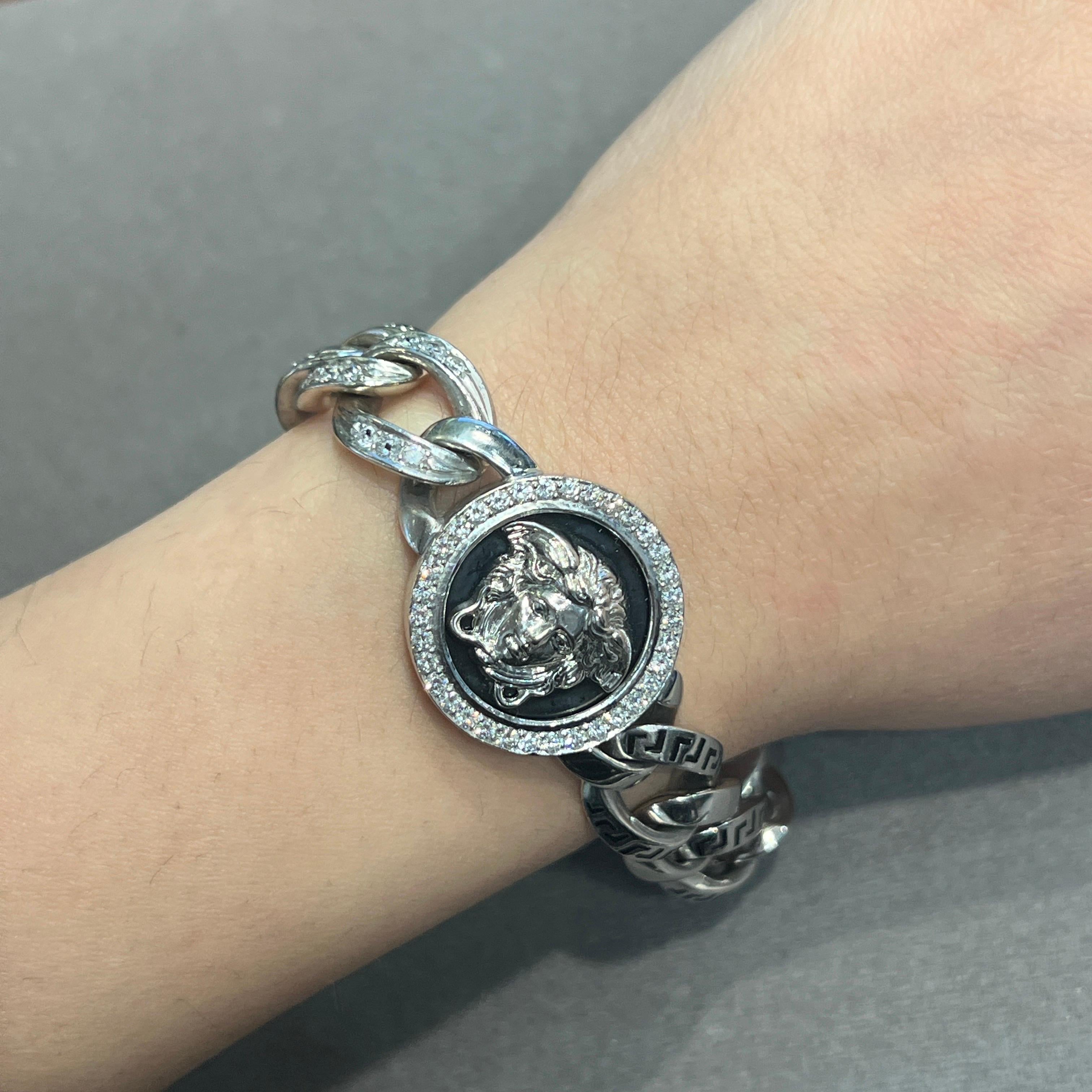 Men's Versace Diamond Link Bracelet 

A white gold link bracelet by Versace featuring three Medusa motifs, each accented with a round-cut diamond halo. Some links are engraved with the Versace logo and set with round-cut diamonds.

Approximate