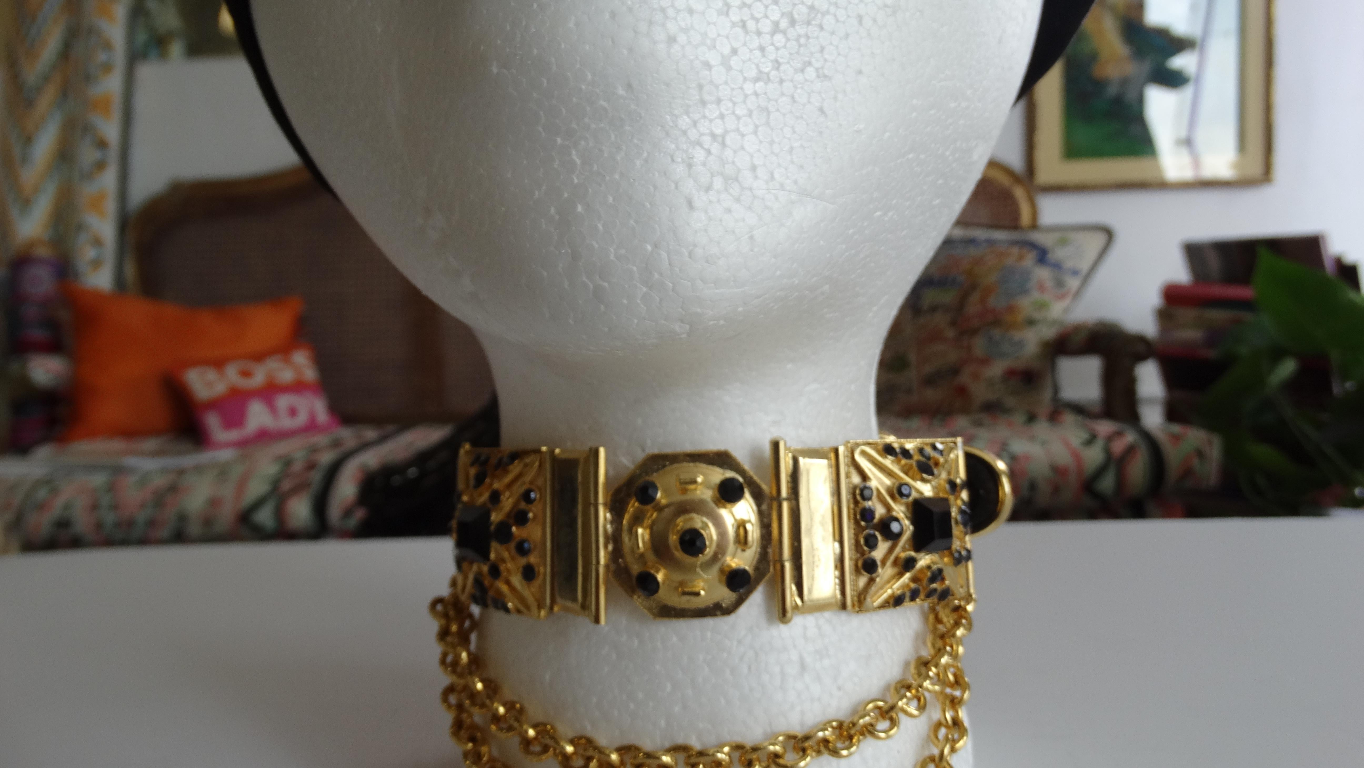 Vintage Versace is always a yes! Circa 1980s, this Gianni Versace gold plated choker includes 3 detailed pendants decorated with blacks rhinestones and a double link chain. Choker features a black suede belt style design and closure. Dress it up or