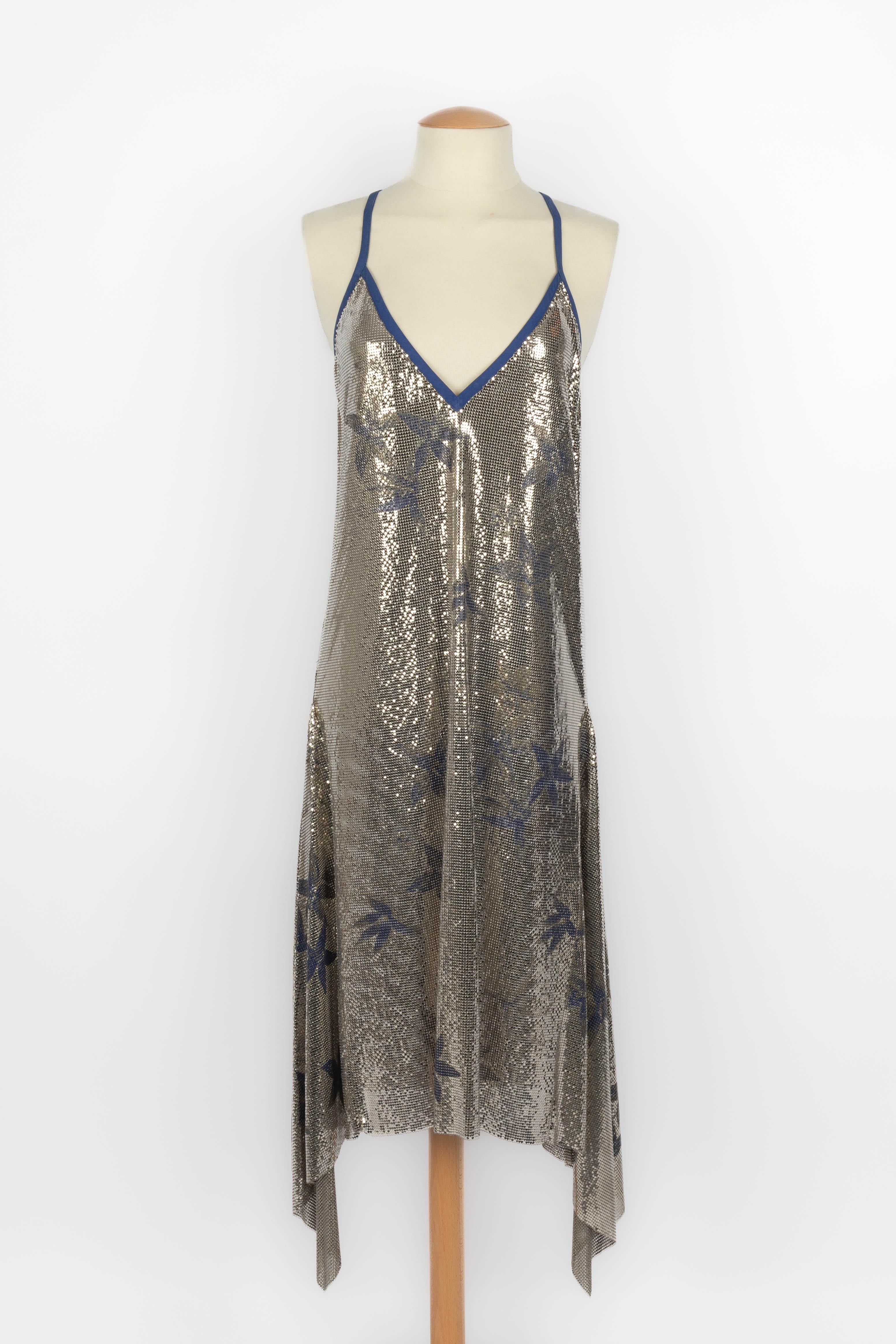 VERSACE - (Fabriqué en Italie) Robe en maille métallique argentée à motif de fleurs bleues. La taille 42IT indiquée correspond à un 38FR. Collectional printemps-été 1983.

Condit :
Très bon état.

Dimensions :
Tour de poitrine : 42 cm - Longueur :
