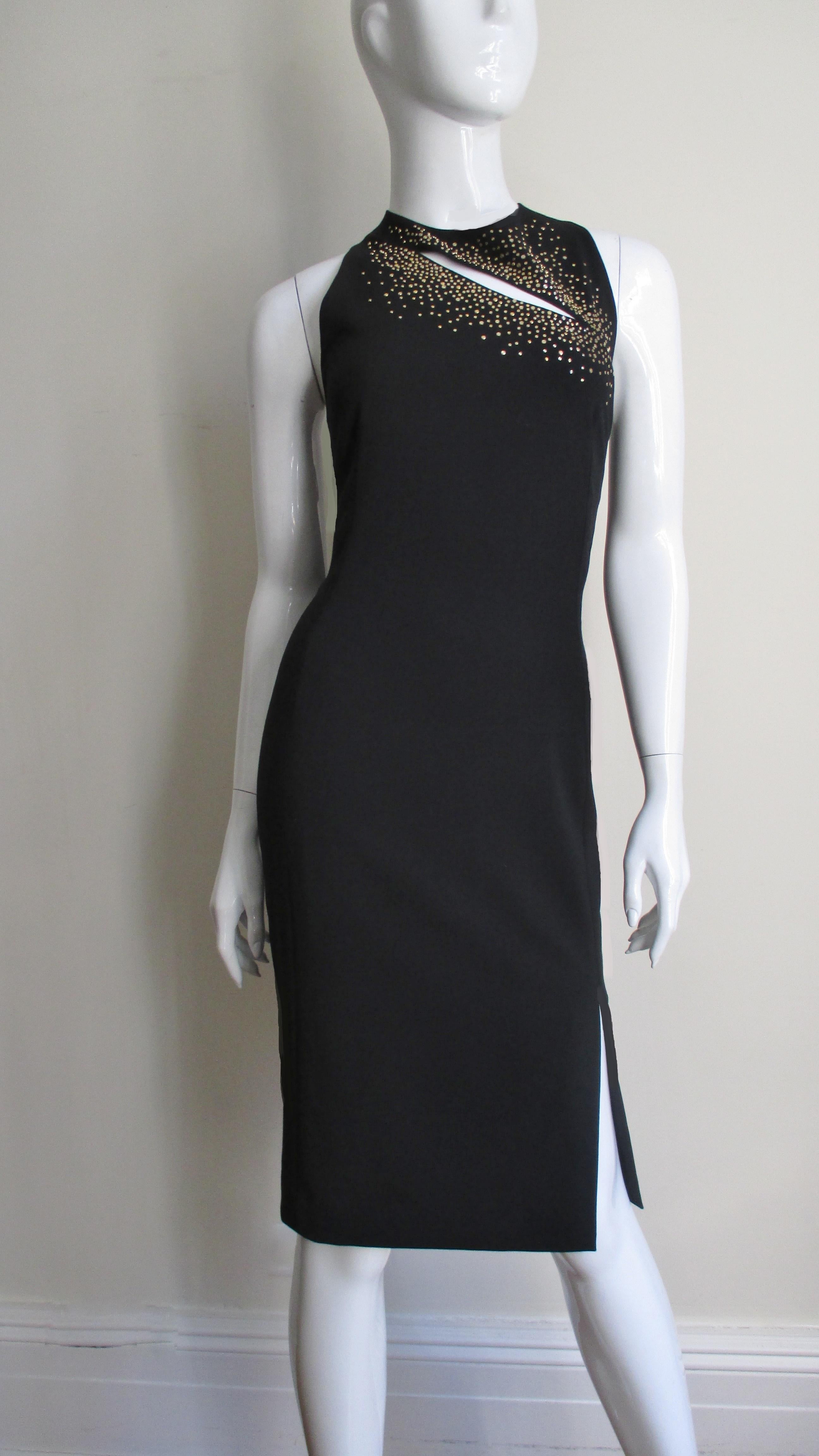 A great black light weight wool blend dress with a touch of stretch from Versace.  It is sleeveless with a crew neckline and a cut out slash diagonally crossing the upper chest framed with dozens of gold nail head studs.  It is fitted with a 9
