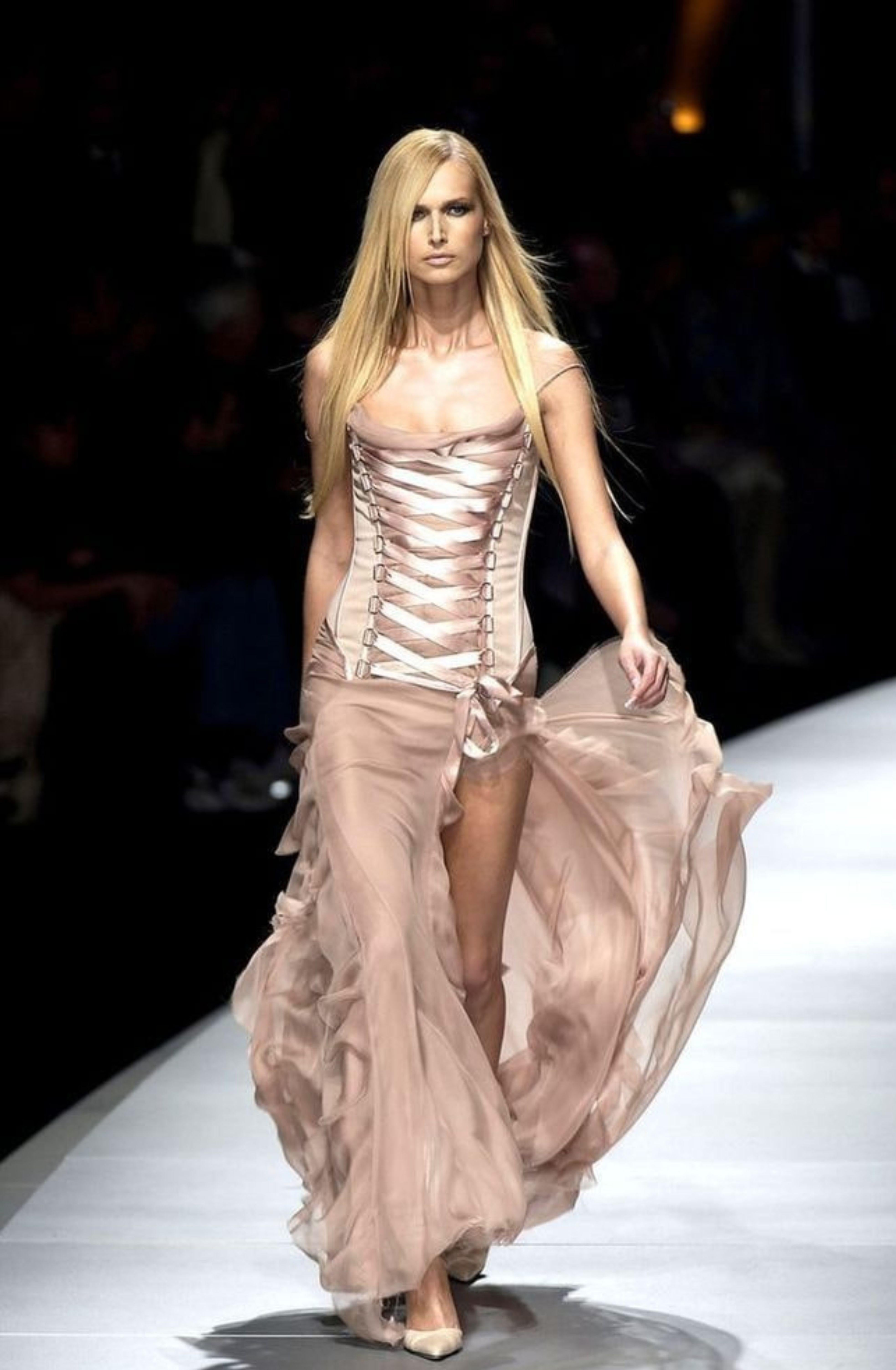 Versace Fall 2003
Seen on the runway,  campaign images, and worn by numerous celebrities including Bella Hadid.

Nude silk chiffon ruffle gown dress with lace up corset front & back.
Thigh slit on one side. 
Boned bodice. 
Zip up side of bodice, and
