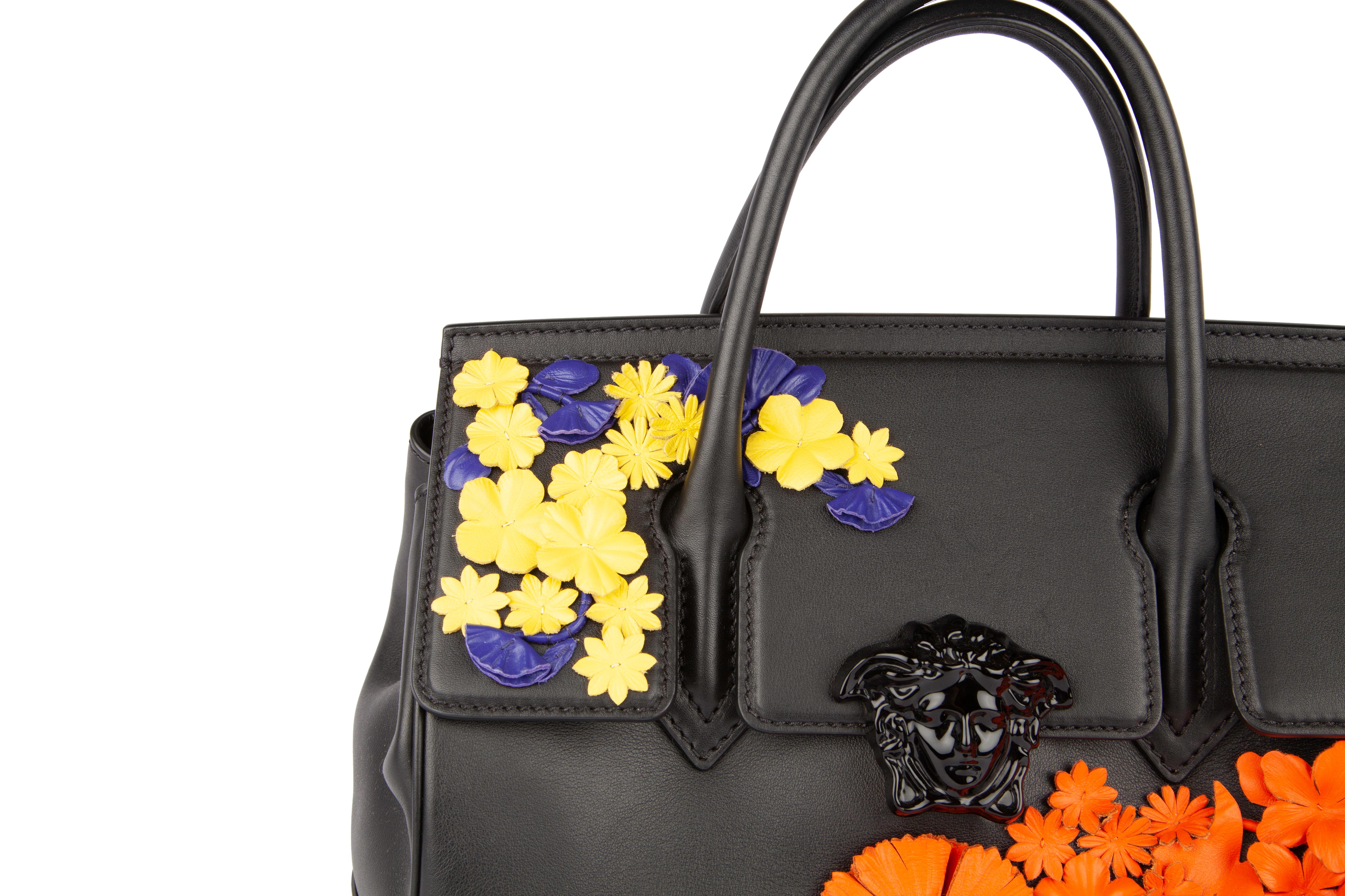 This Versace multi-color leather Palazzo Empire bag features a beautifully hand-sewn flower appliqués, a magnetic snap fastening, and the iconic Versace medusa head front and center. This item is brand new and never owned, however it was the store