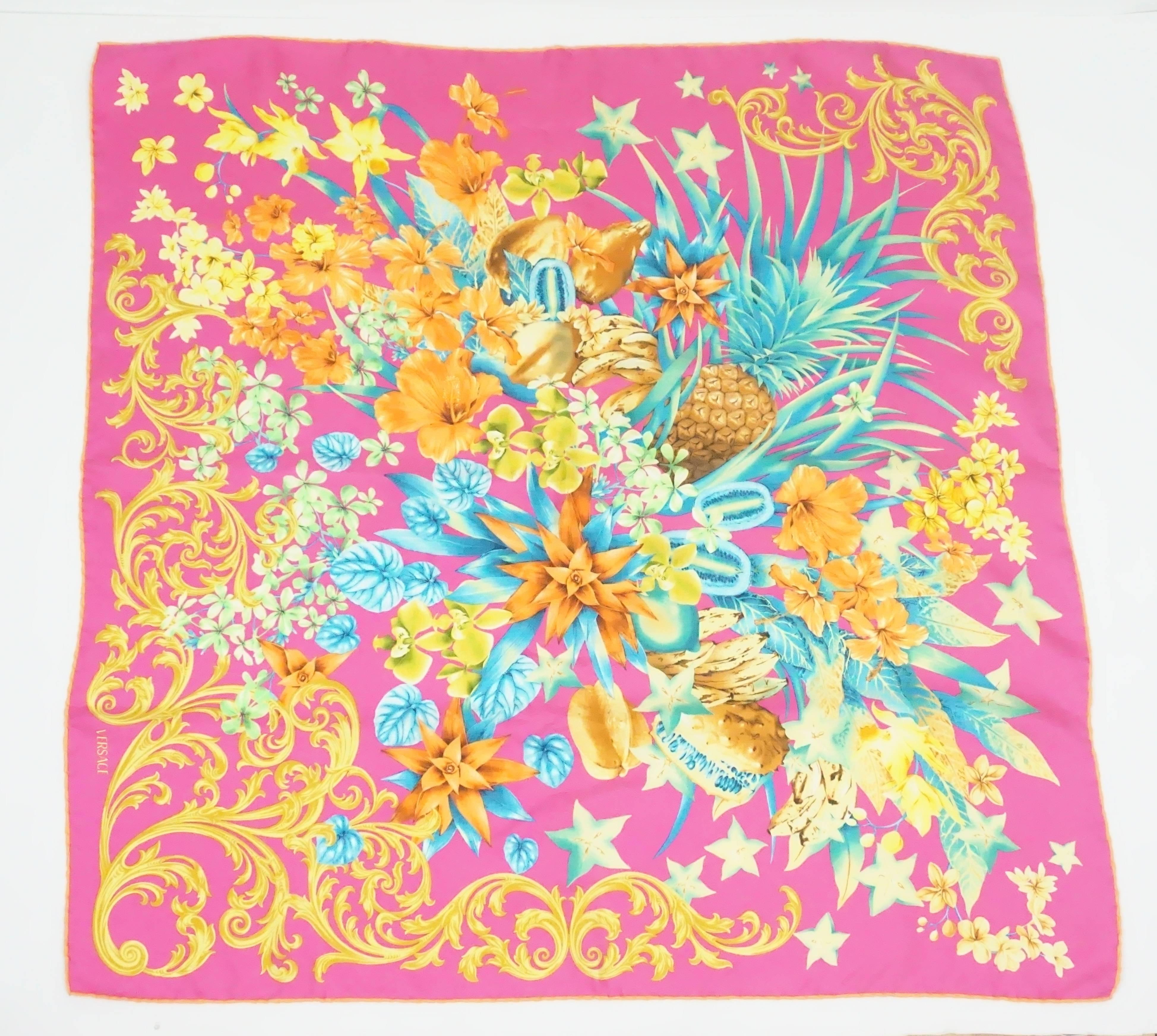 Versace Fuchsia and Multi Floral Print Scarf  This Versace silk scarf has a mixture of green, fuchsia, and orange colors. There is a tropical theme to it with the pineapple towards the middle, the tropical flowers and the palms. This item is in