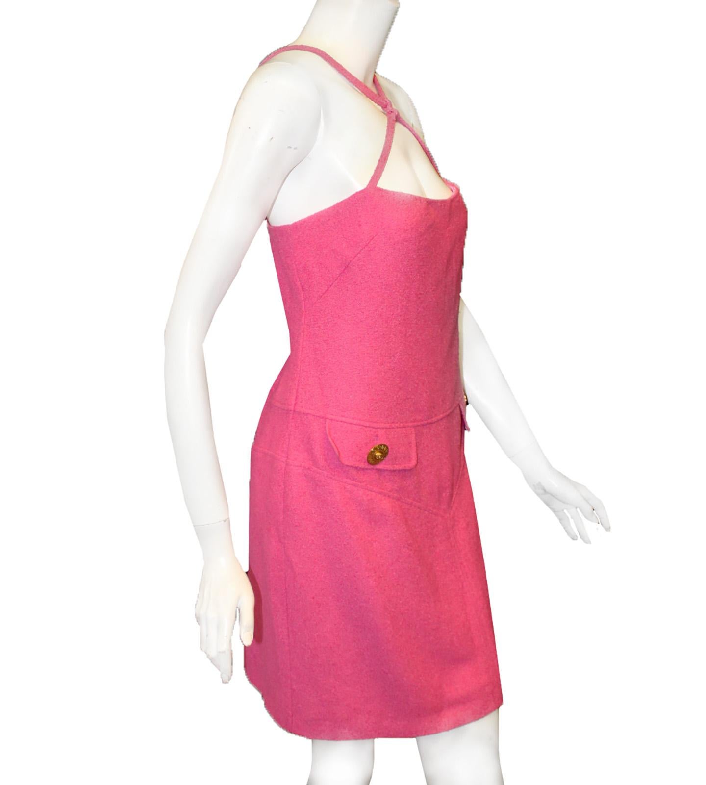 Versace fuschia crisscross strap dress features two faux front flap pockets enhanced by a gold tone signature Versace button.  Thin straps crisscross at the decolletage and terminate at the back.  This modern A line summer dress is fully lined in