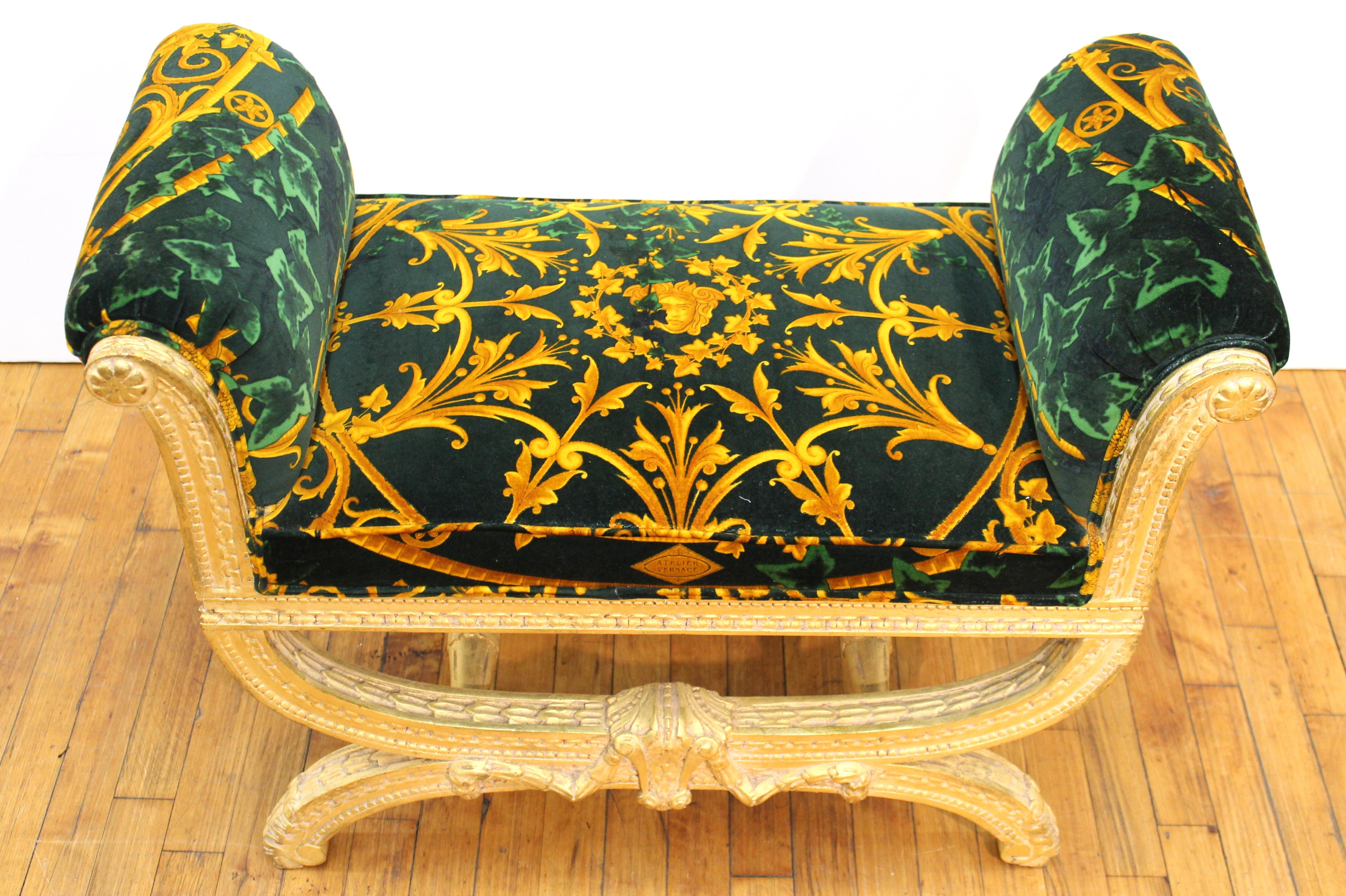 Versace Italian gilt wood frame bench with Versace velvet upholstery in bright gold and green with baroque design elements. The piece was made in the 1980s and has the Versace logo on the front of the velvet.