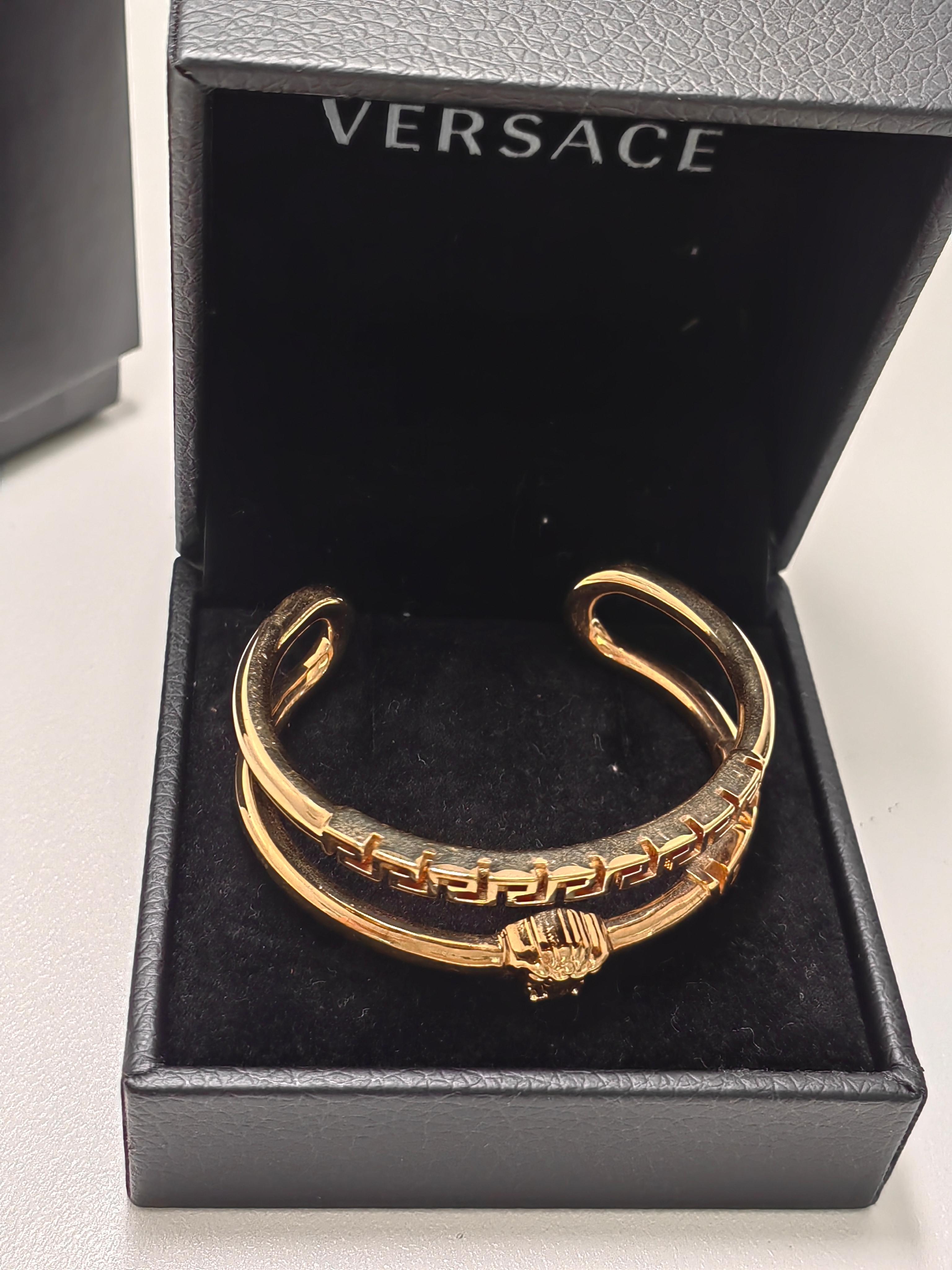 Brazalete abierto de latón dorado. - Logotipo, firma de Medusa y diseño de llave griega en la parte frontal - Logotipo grabado en la banda interior - Alto 0,75 x Ancho 2,25 x Ancho 1,75 Color del proveedor: Dorado
Latón.

Talla pequeña