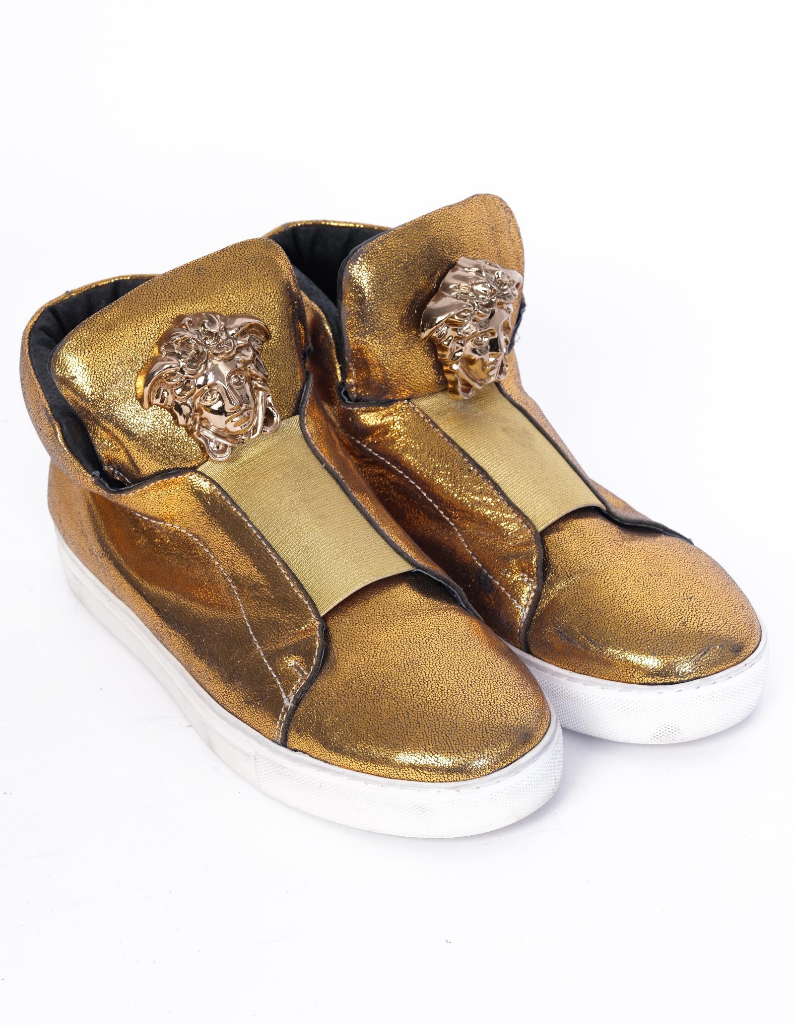 These shoes are made with leather with a metallic gold finish. Featuring the iconic Versace Medusa emblem, white soles and a black interior.

COLOR: Gold & white
ITEM CODE: 188-6A 
MATERIAL: Leather 
SIZE: 43 EU / 10 US
EST. RETAIL: $1500
CONDITION:
