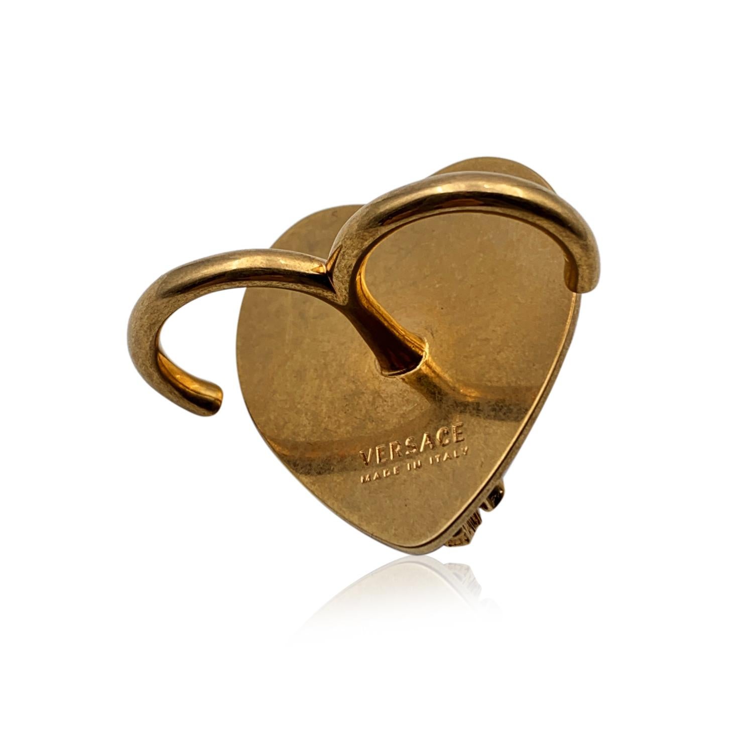 Beautiful Versace Virtus Heart Statement Double Ring. Crafted of red resin with red rhinestones embellishment and big gold metal V letter on top. Size: S. Max width on the top: 1.5 inches -3.5 cm. 'Versace - Made in Italy' engraved on the