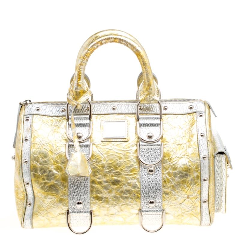 This bold and eye-catching Versace Snap Out Of it satchel is sure to make heads turn. Crafted from ceramic effect leather the bag is accented with a Gianni Versace Couture plate and silver-tone studded hardware. It features dual top handles and a