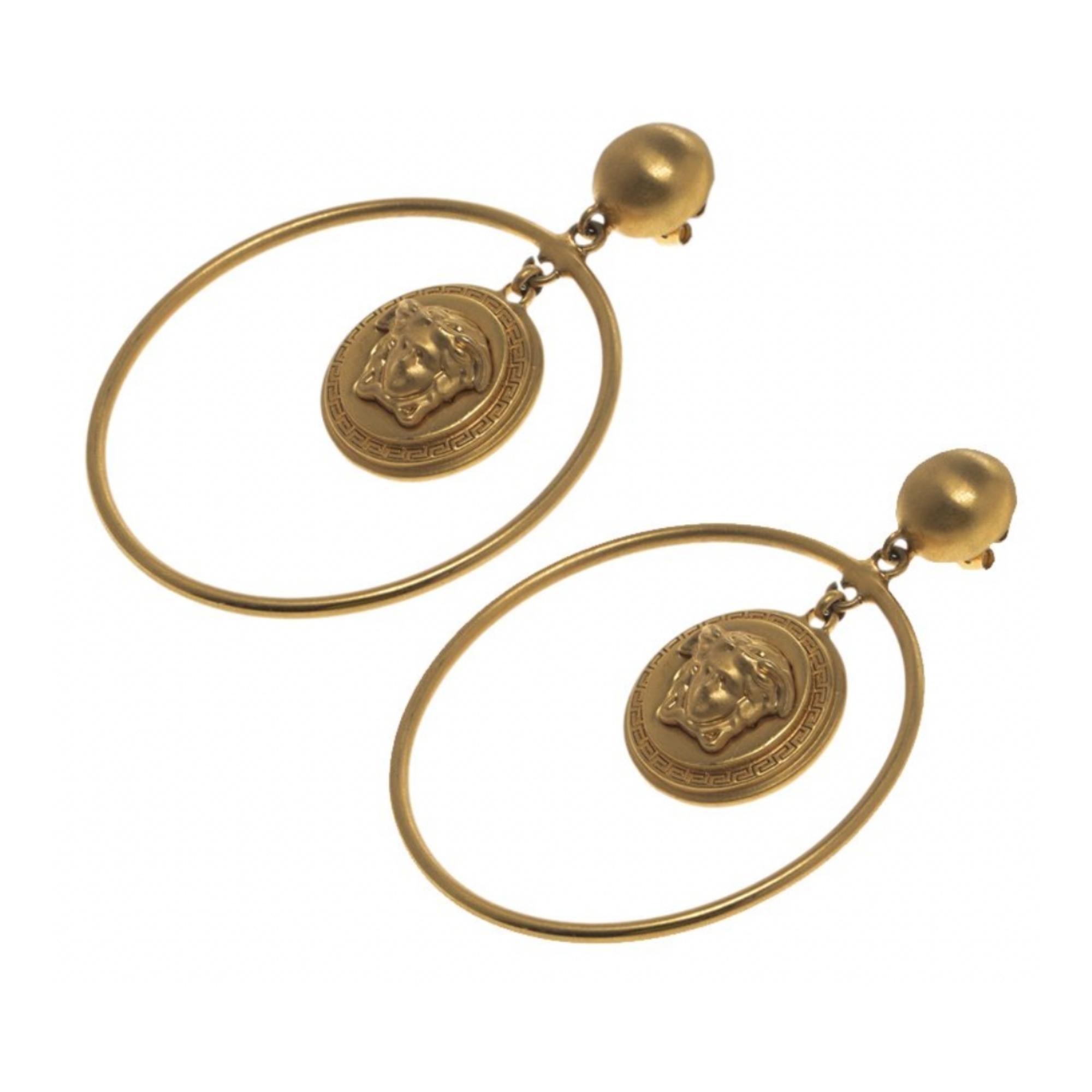 These Versace earrings are feminine and modish. Constructed from gold-tone metal, the pair carries the famous Medusa emblems dangling within hoops.

Color: Gold tone
Material: Metal
Marks: VERSACE Made in Italy
Clasp Style: For pierced ears
Year: