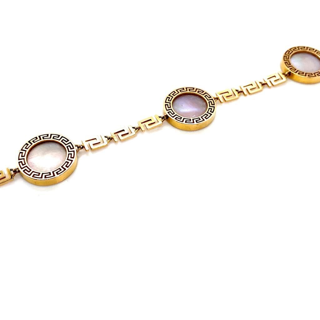 A vintage Versace Greca mother of pearl 18 karat rose gold bracelet.

This elegant disc bracelet is from a discontinued design from Versace's 'Greca’ collection. 

Designed with four circular charms set with mother of pearl connected with