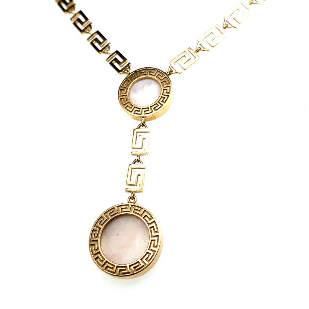 Vintage Versace Greca Perlmutt-Halskette aus 18 Karat Roségold

Diese elegante Scheiben-Halskette ist ein Auslaufmodell aus der 'Greca'-Kollektion von Versace. 

Das Design besteht aus zwei kreisförmigen, mit Perlmutt besetzten Anhängern in der
