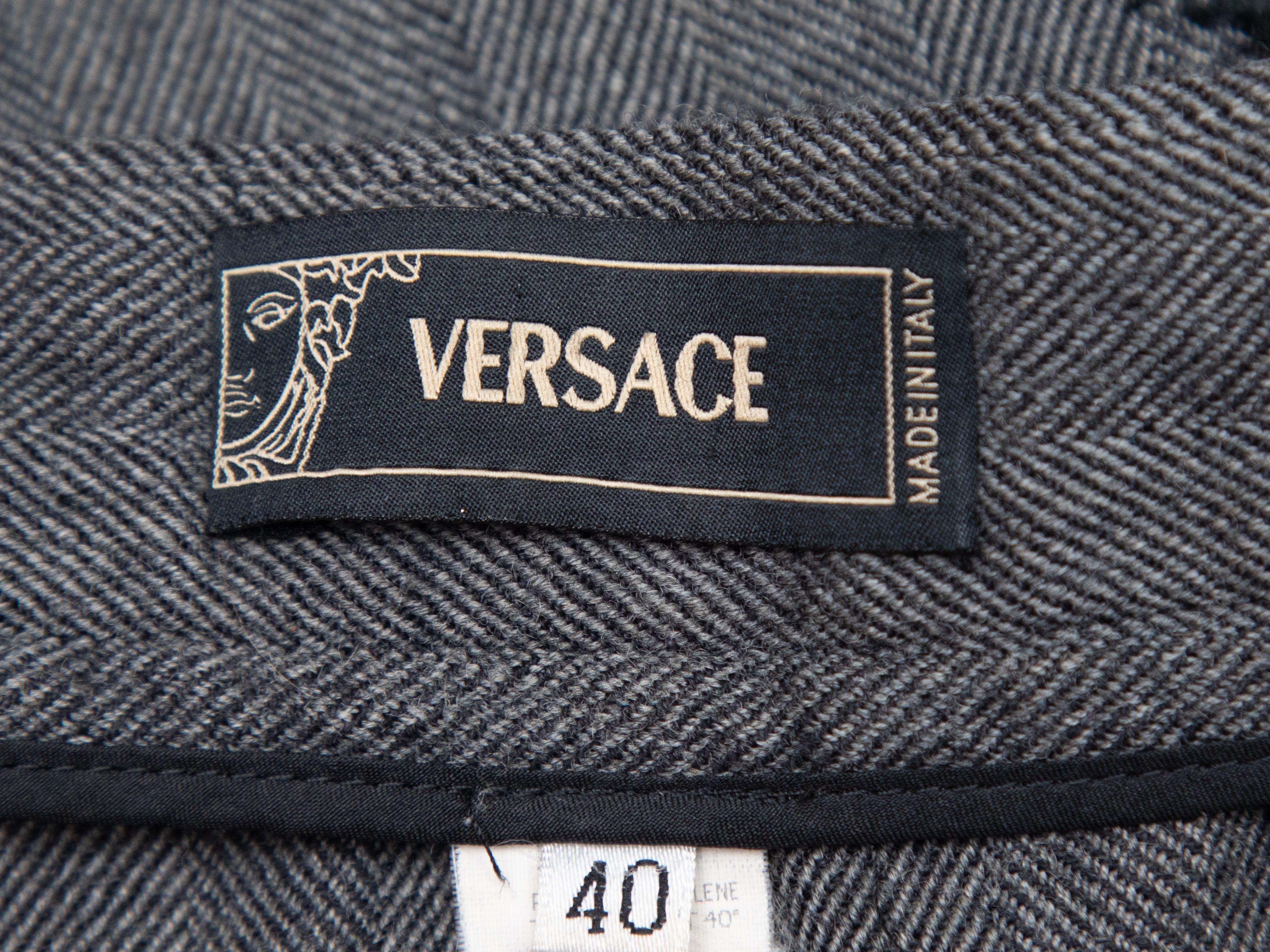 Product Details: Vintage grey herringbone wool bootcut pants by Versace. Sheer black lace panels at sides. Zip closure at front. 28