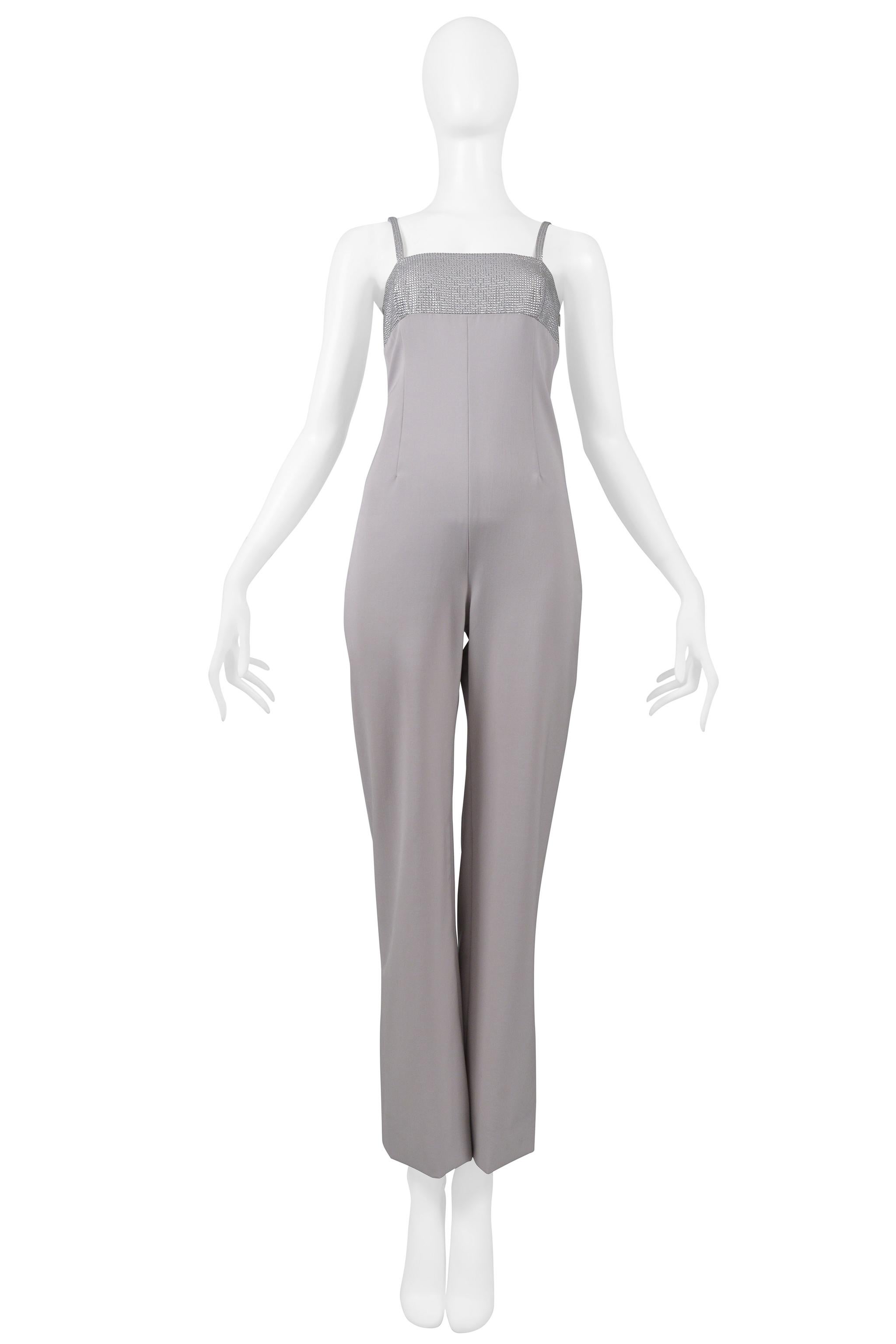 Resurrection Vintage is delighted to offer a vintage Versace jumpsuit from the 1998 collection. The jumpsuit features a straight neckline, silver dot beaded chest and shoulder straps, a darted torso and back side, an ankle-length bottom, and an
