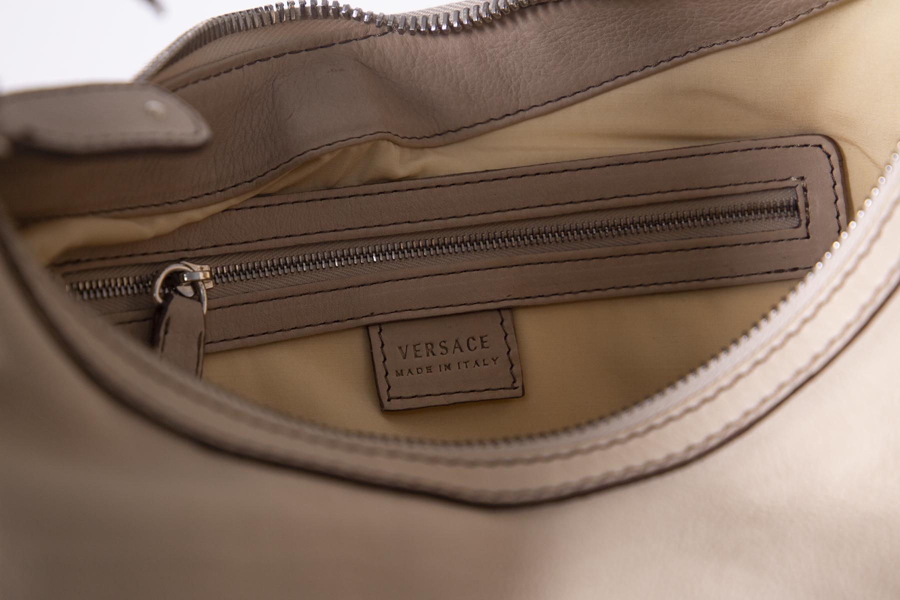 Hobo women bag by the Italian stylist Gianni Versace in 90s.
Designed in a unique and beautiful silhouette, this Versace hobo bag will be a special addition to any wardrobe. It is made of calfskin fi leather with suede inserts and is finished with