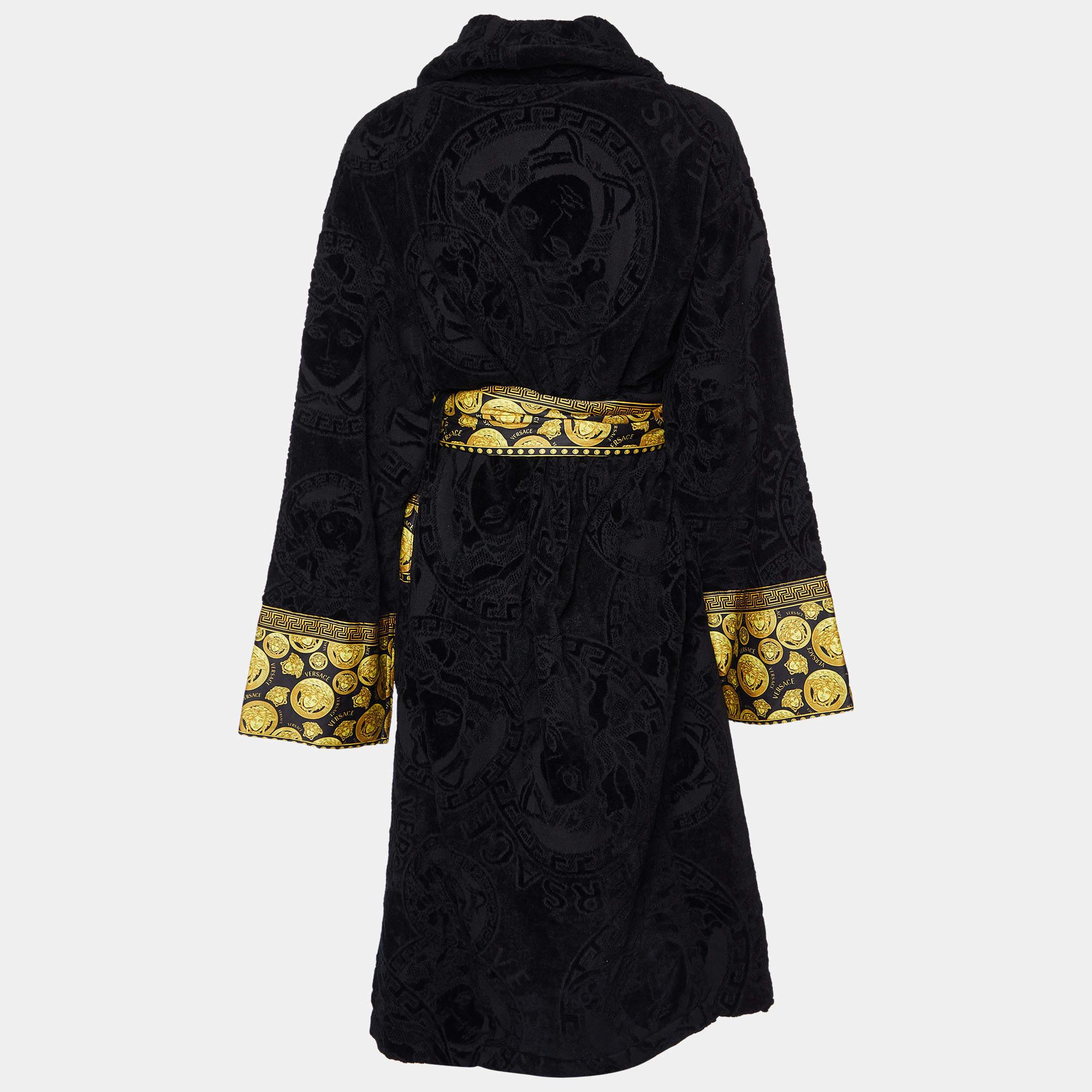 Indulge in luxury with the Versace bathrobe. Crafted from sumptuously soft terry cotton, adorned with the iconic Versace Baroque motif, and featuring a flattering tie-waist design, this bathrobe promises unparalleled comfort and style for your